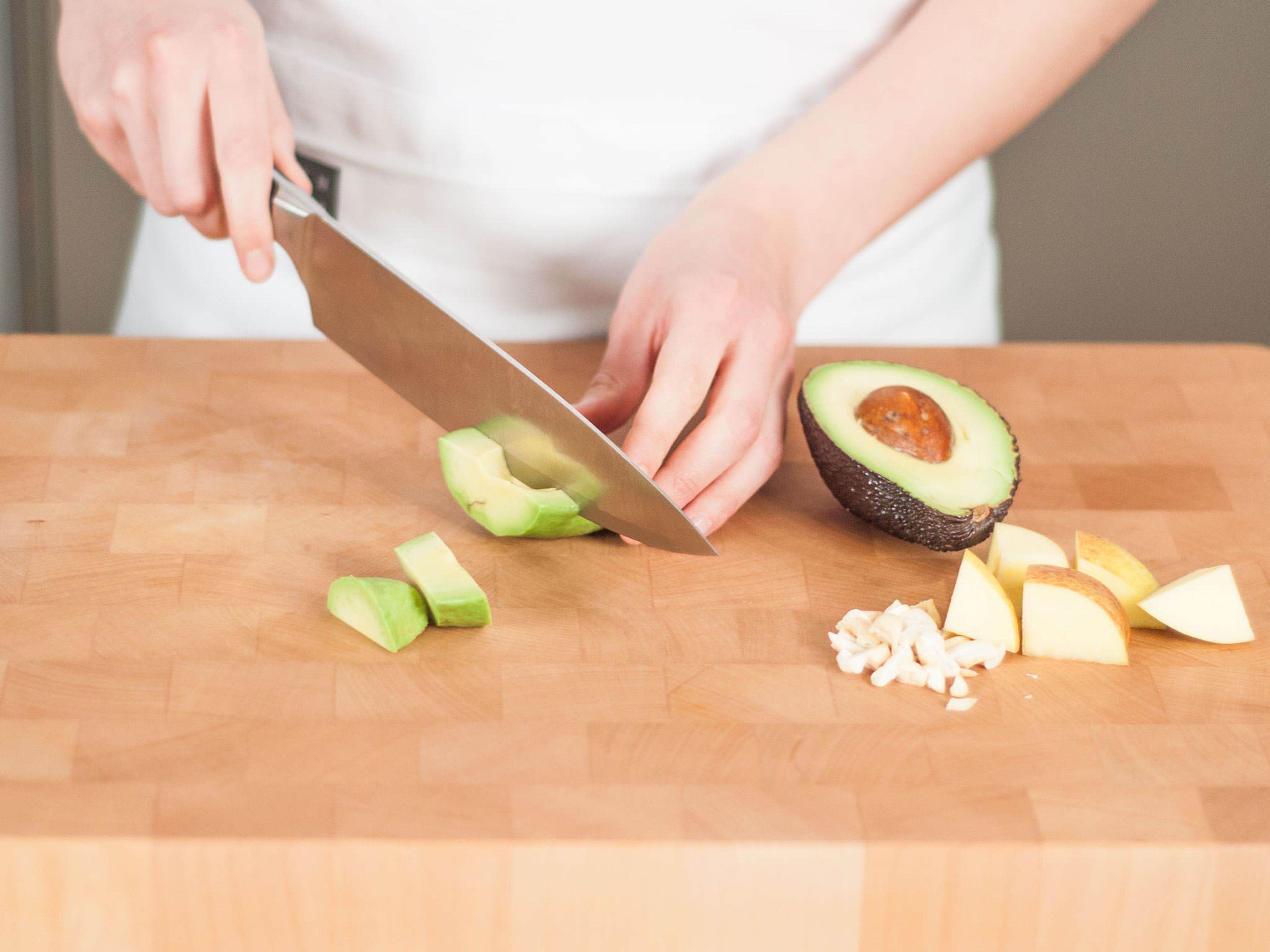 Roughly chop apple, cucumber, cashews, and avocado.