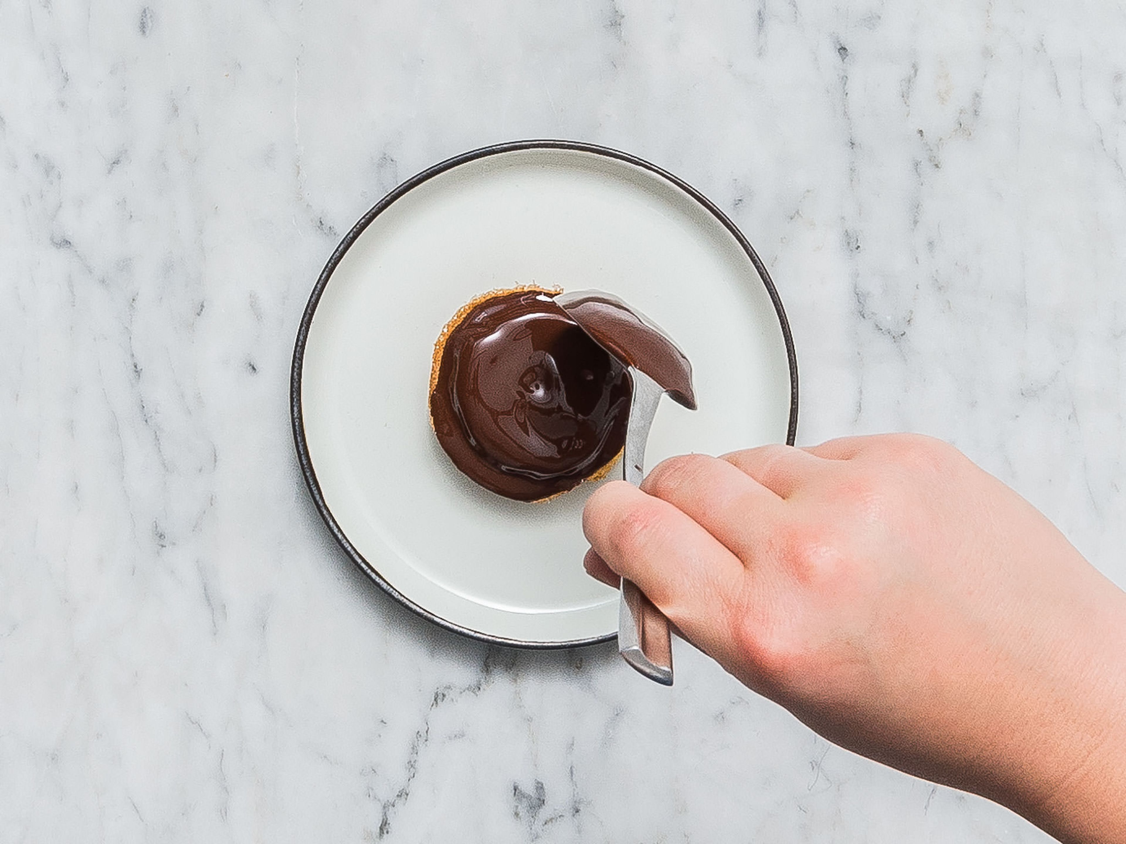 Zartbitterschokolade hacken und zwei Drittel der Schokolade in einer hitzebeständigen Schüssel über einem Topf mit köchelndem Wasser schmelzen. Die restliche gehackte Schokolade dazugeben und schmelzen lassen. Vom Herd nehmen und ca. 10 Min. abkühlen lassen. Je 1 - 2 EL der geschmolzenen Schokolade auf jeden Soft Cake geben und vorsichtig bis zum Rand verteilen. Im Kühlschrank ruhen lassen, bis die Schokolade fest ist. Guten Appetit!