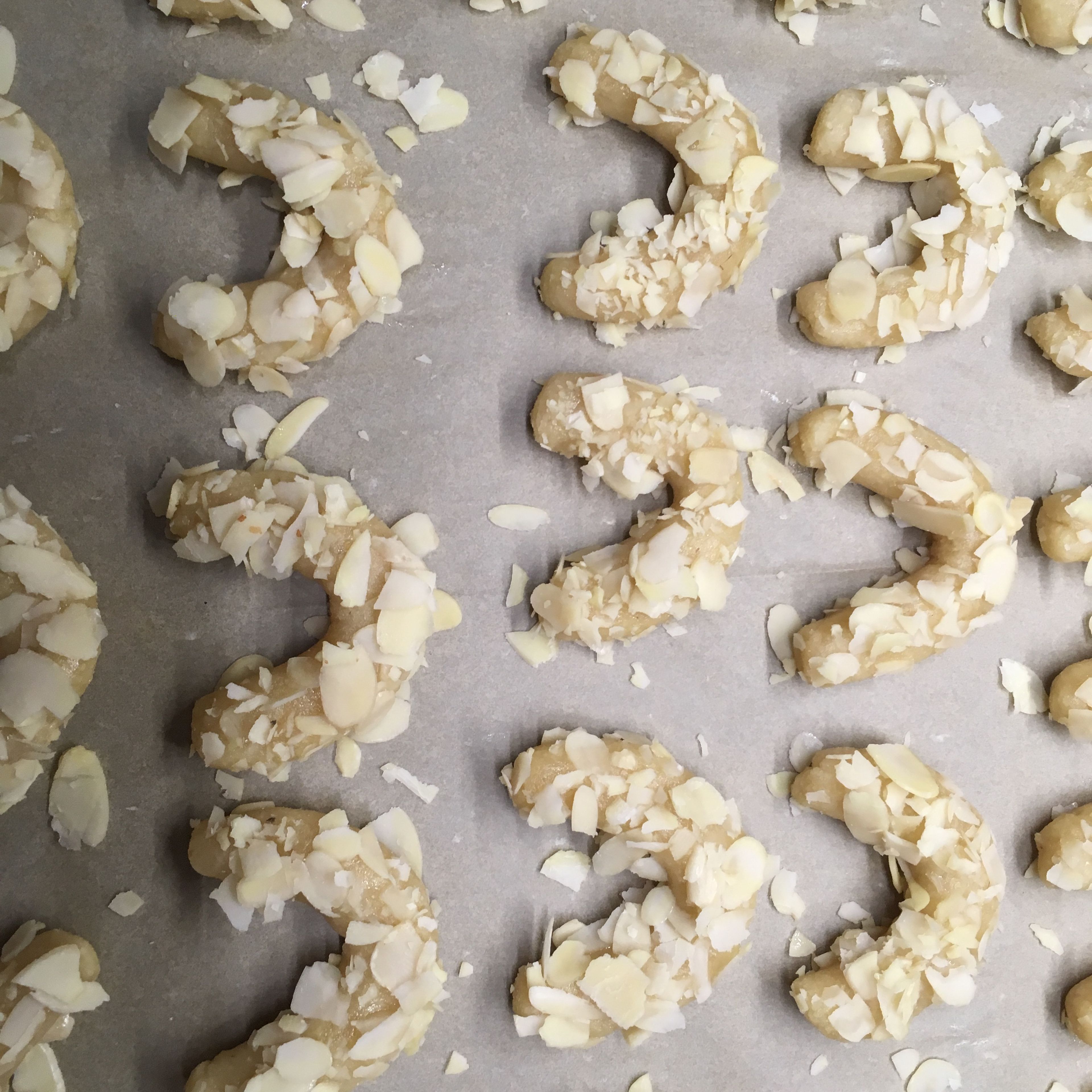 Brush each of the croissants with egg white and press into the sliced almonds. I crush the almond flakes so they stick better to the little crescents. Place on a lined baking sheet.