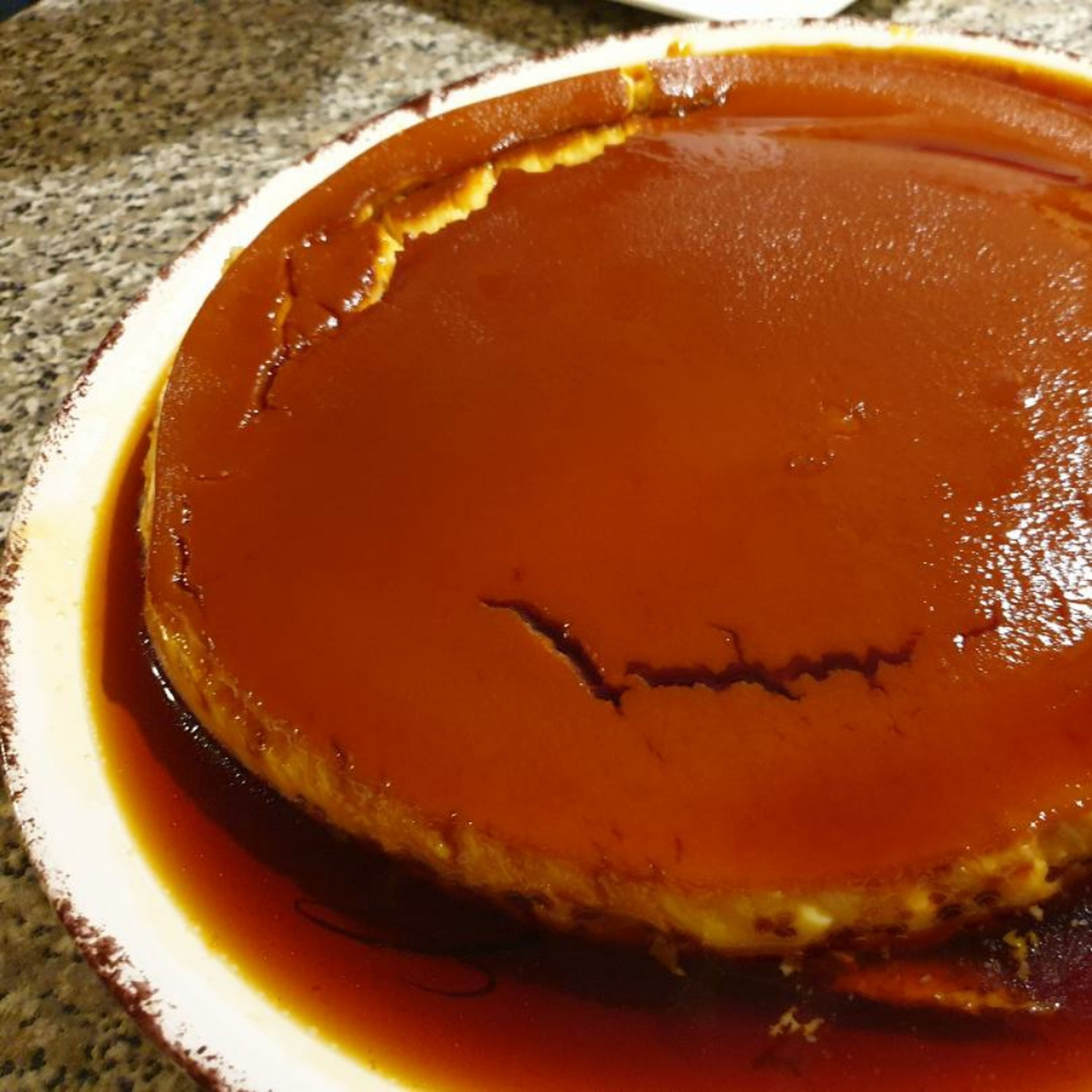 Using a large plate, place it on top of the round baking dish and turn it over, displaying the caramelised layer on the top.