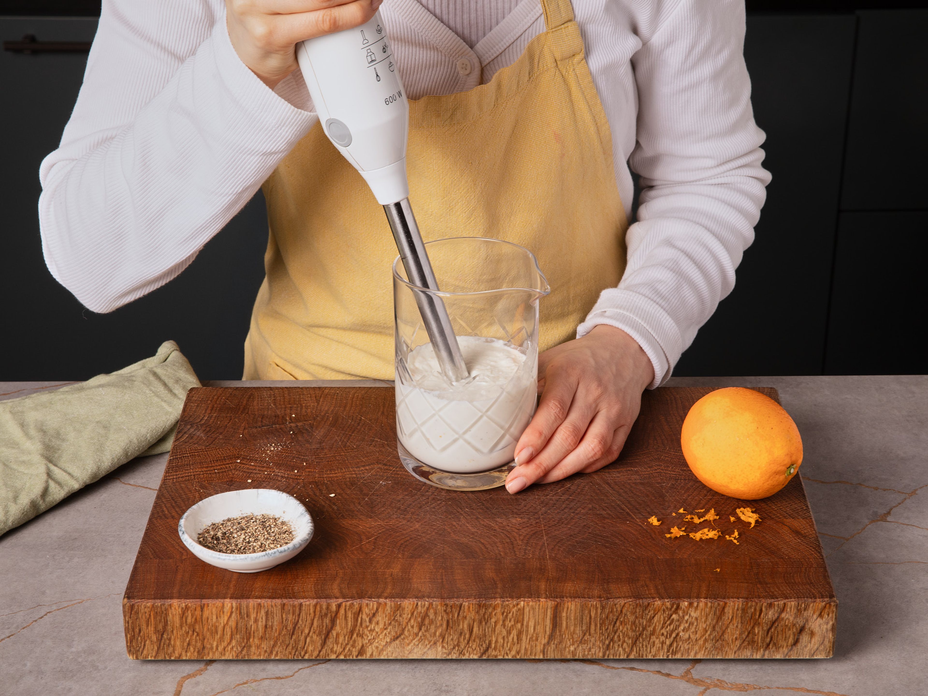 Für die Feta-Creme den Feta zusammen mit dem gebratenen Knoblauch, Joghurt, Wasser, etwas Orangenzeste und etwas Pfeffer in einen Standmixer oder ein hohes Gefäß geben und in dem Mixer oder mit einem Pürierstab zu einer glatten, cremigen Masse verarbeiten.