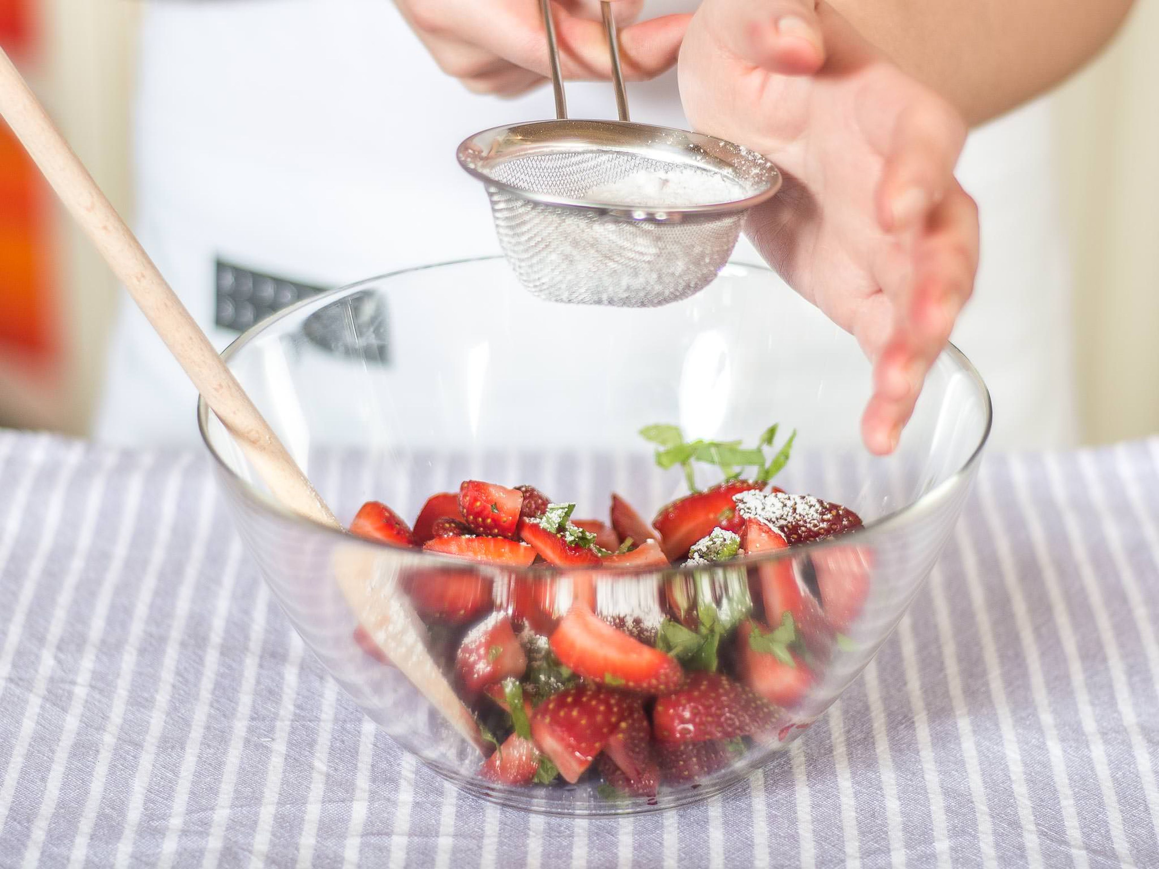 Erdbeeren und Minze mit einem Teil Puderzucker vermengen und beiseitestellen. Der Zucker verleiht den Erdbeeren einen schönen Glanz.
