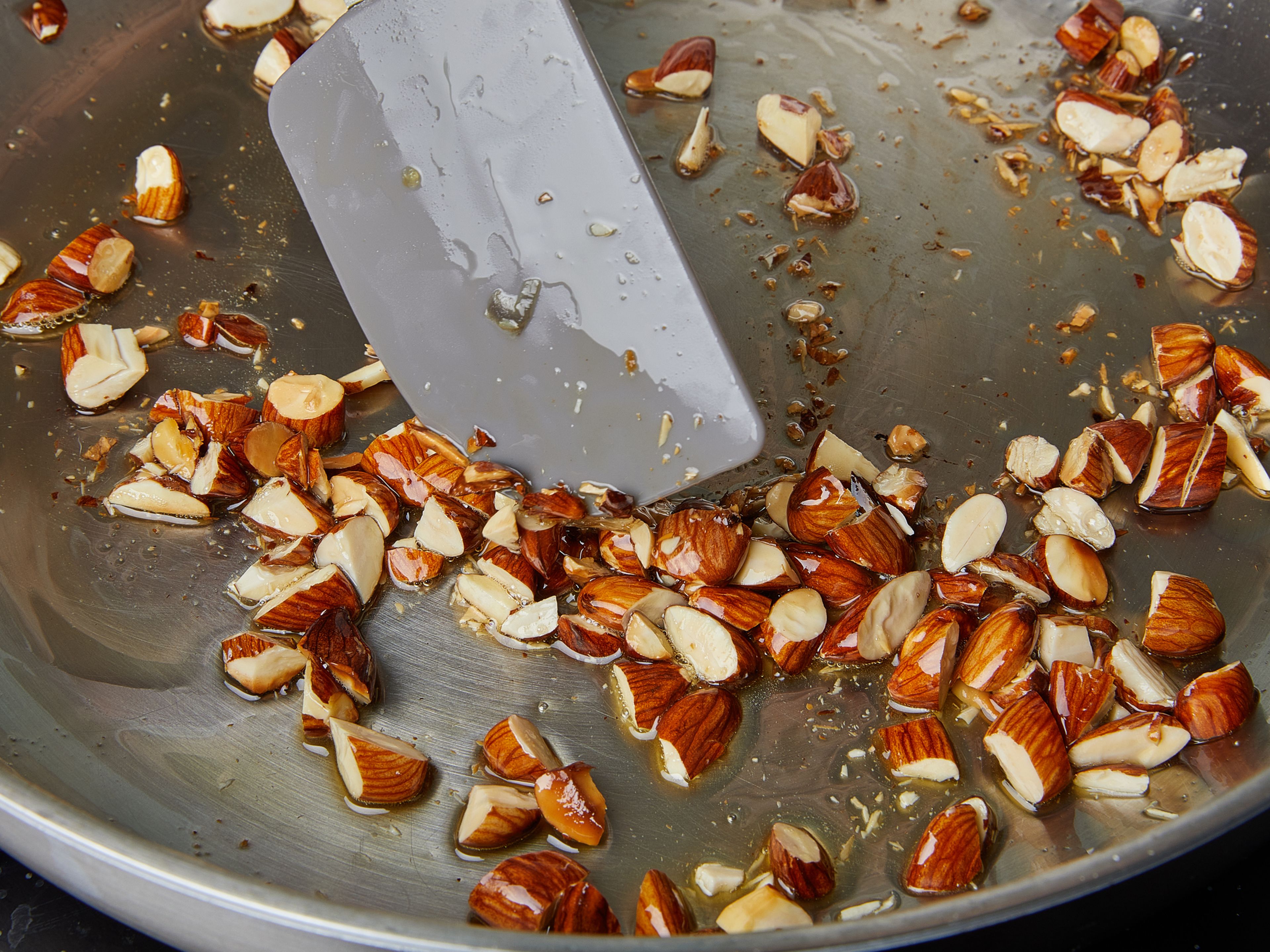 Add remaining olive oil to the pan and add almonds once hot. Fry until golden brown, watch closely, remove from heat and add to a small bowl. Season with salt and chilli flakes.