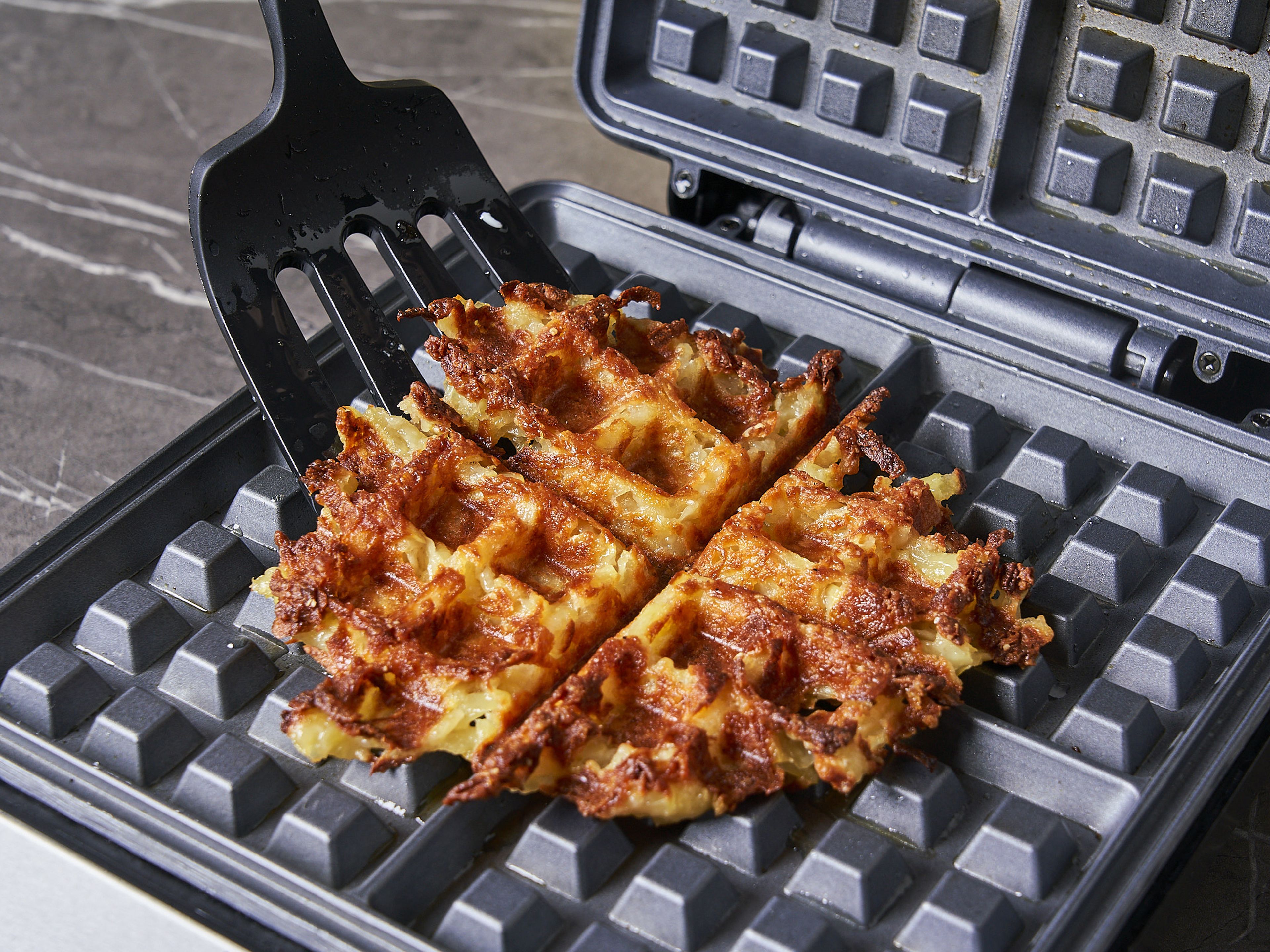 Once the waffles are cooked, remove them from the waffle iron and place them on a plate. Top each waffle with 2 strips of bacon, cornichons, and a fried egg. Season with salt and pepper, garnish with chives. Serve immediately with the paprika mayonnaise.