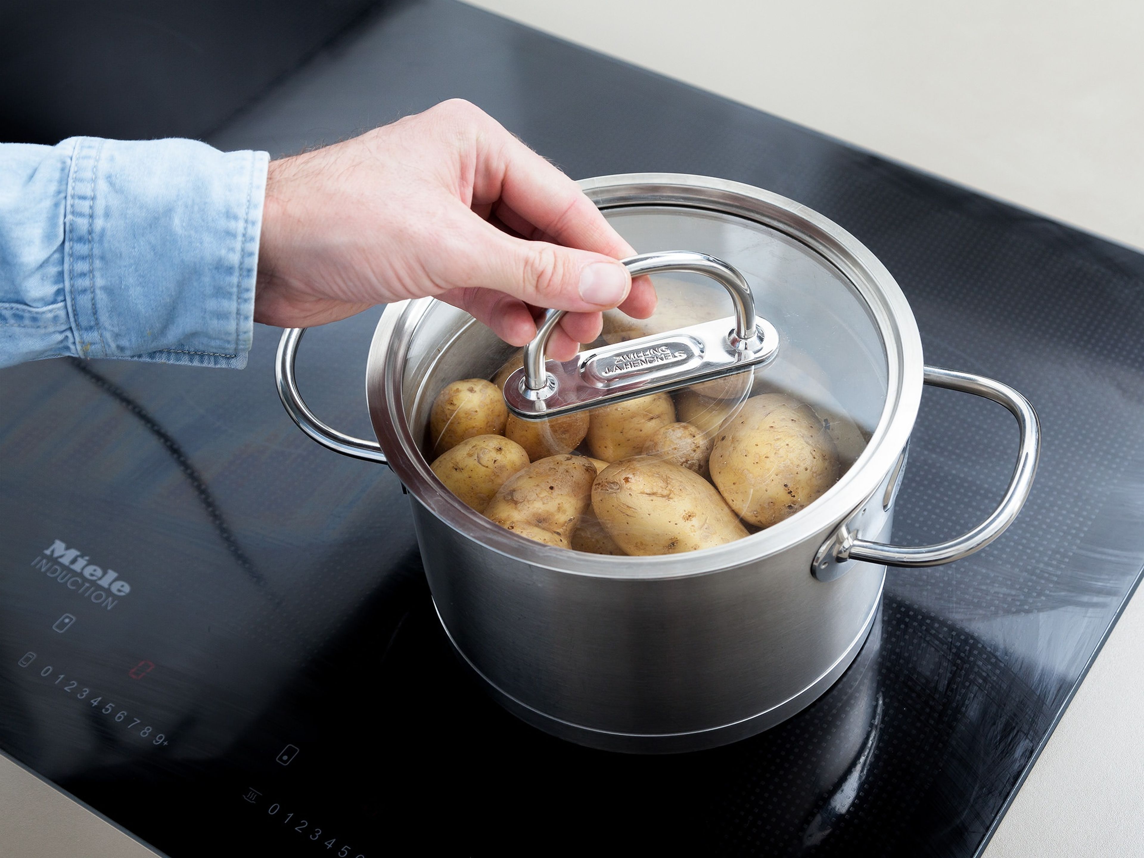 Für unser Kartoffelsalat Rezept zuerst Kartoffeln unter klarem Wasser abspülen und in einen großen Topf mit Wasser geben. Großzügig salzen und die Kartoffeln über mittlerer Hitze ca. 20 Min. köcheln. Anschließend abgießen und abkühlen lassen.