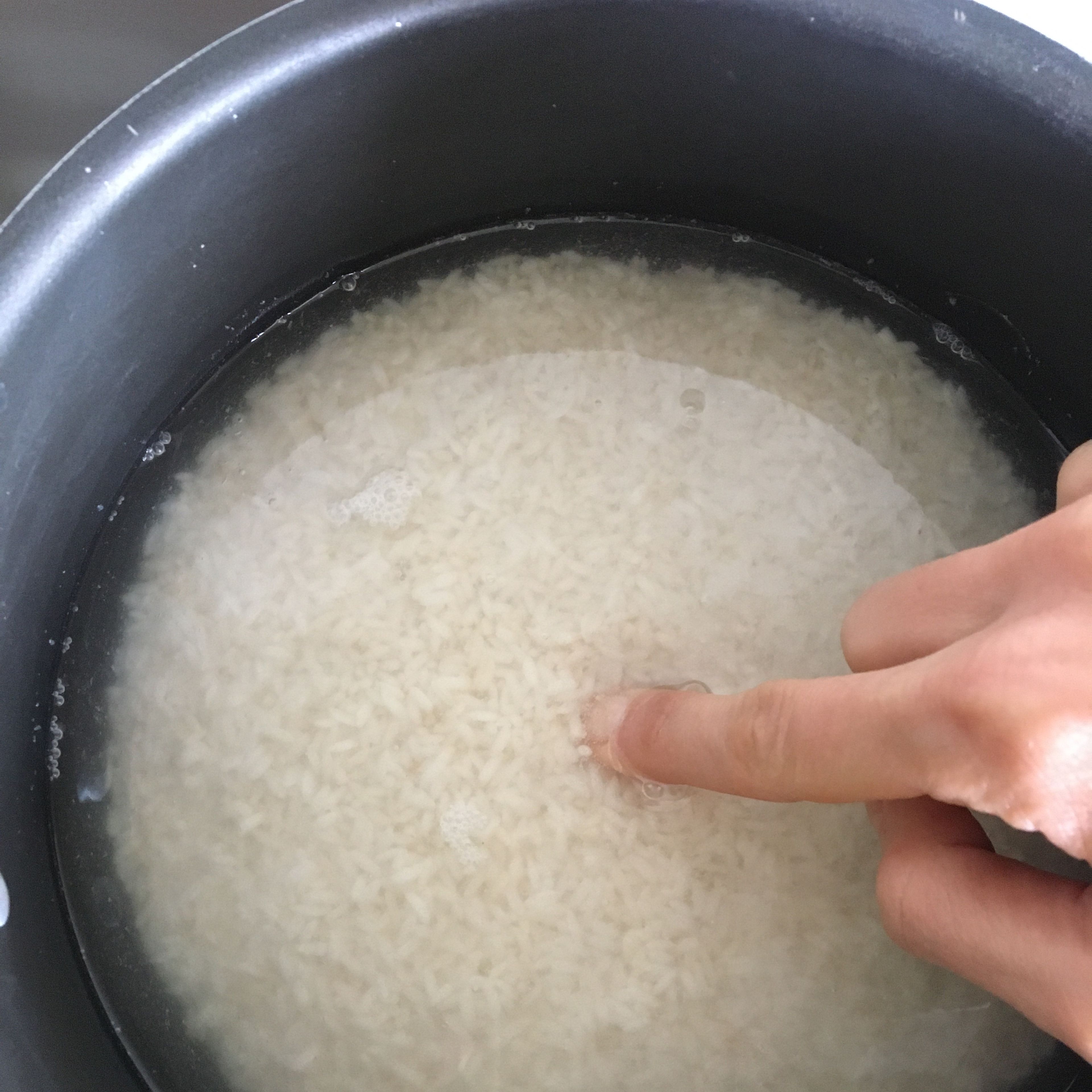 Finley rinse the rice under cold water. Add rice, water and a generous pinch of salt into a medium pot. The water should stand about less than 1cm. above the rice level. Cook over medium-high heat until the water absorbed and the rice is one step before getting al dente.