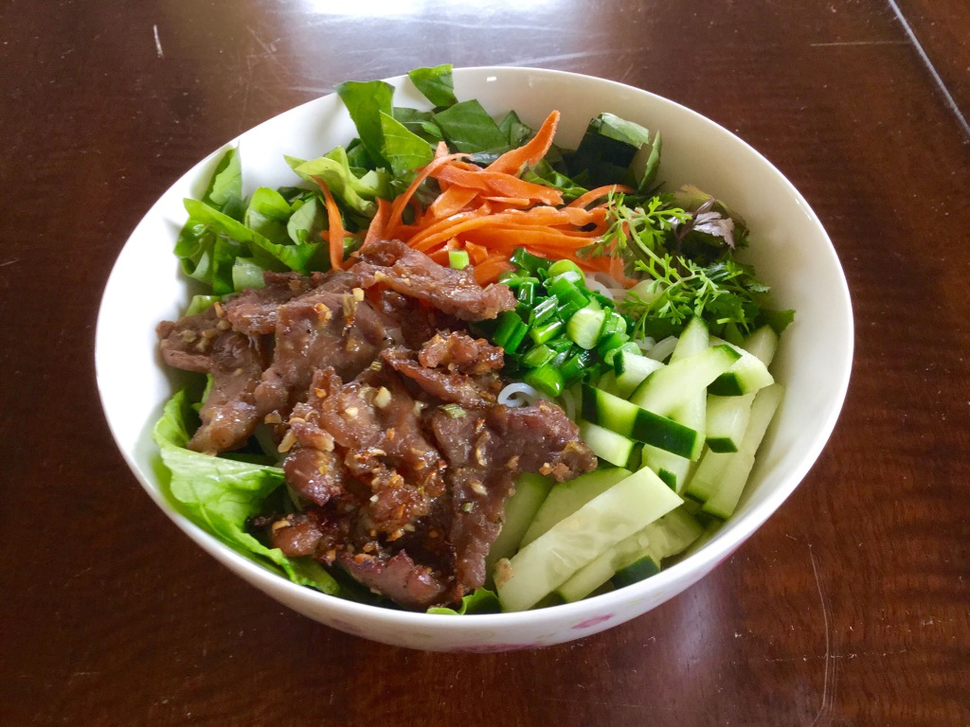 Add lettuce and rice noodles to a serving bowl. Top with other vegetables and baked pork. Add the sauce, serve, and enjoy!