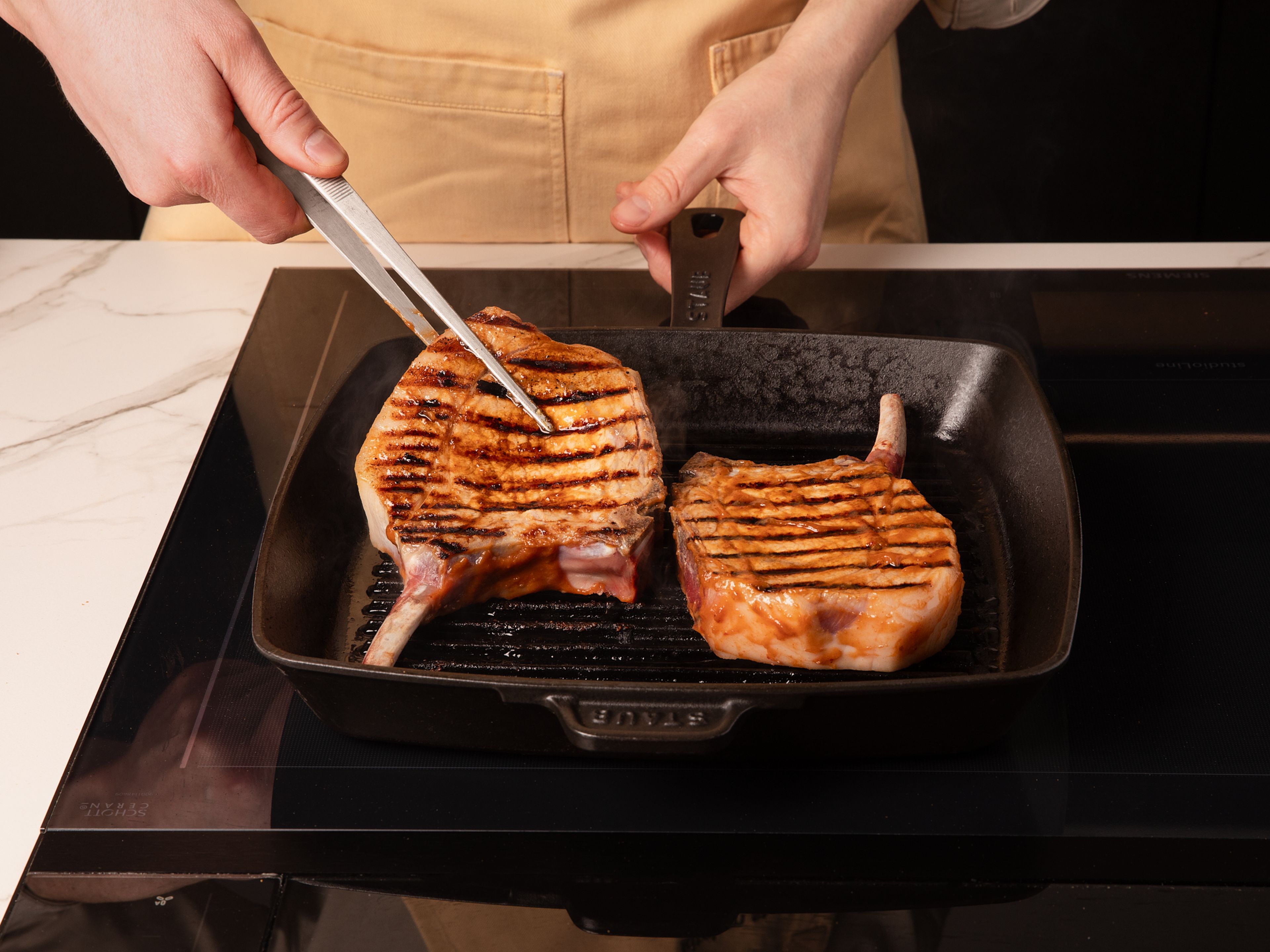 Die marinierten Koteletts aus dem Kühlschrank nehmen und auf Zimmertemperatur bringen. Den Grill oder eine Grillpfanne auf mittlere bis hohe Hitze vorheizen. Die Koteletts 3–4 Min. pro Seite grillen, bis sie eine schöne Kruste bekommen haben. Dabei immer wieder mit der Marinade bestreichen, um sie zu glasieren. Vom Grill nehmen und kurz ruhen lassen.