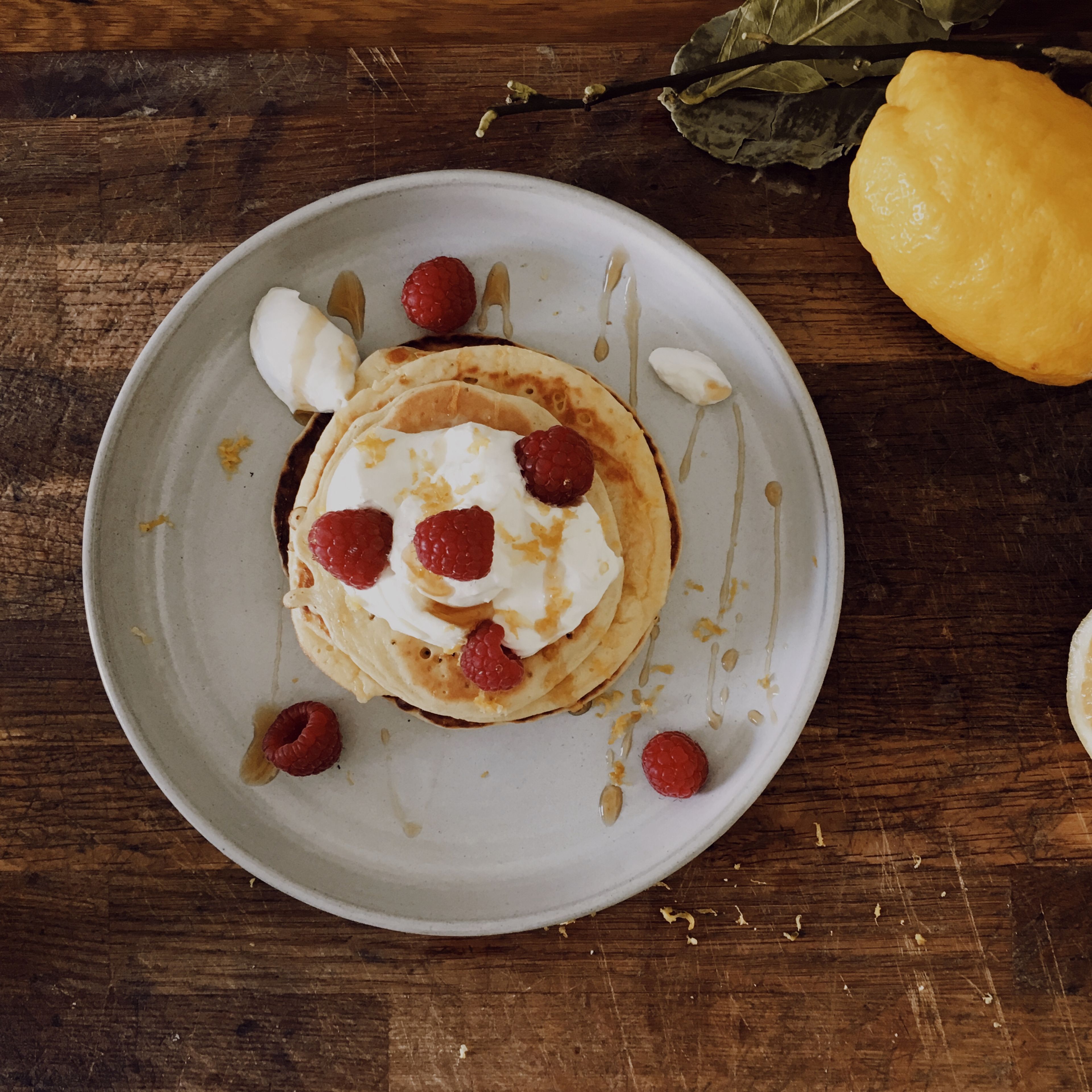 Add the lemon zest, lemon juice and sugar to the mascarpone in a bowl and stir into a smooth cream using a hand mixer with beaters. Serve pancakes with lemon mascarpone cream, maple syrup and lemon zest.