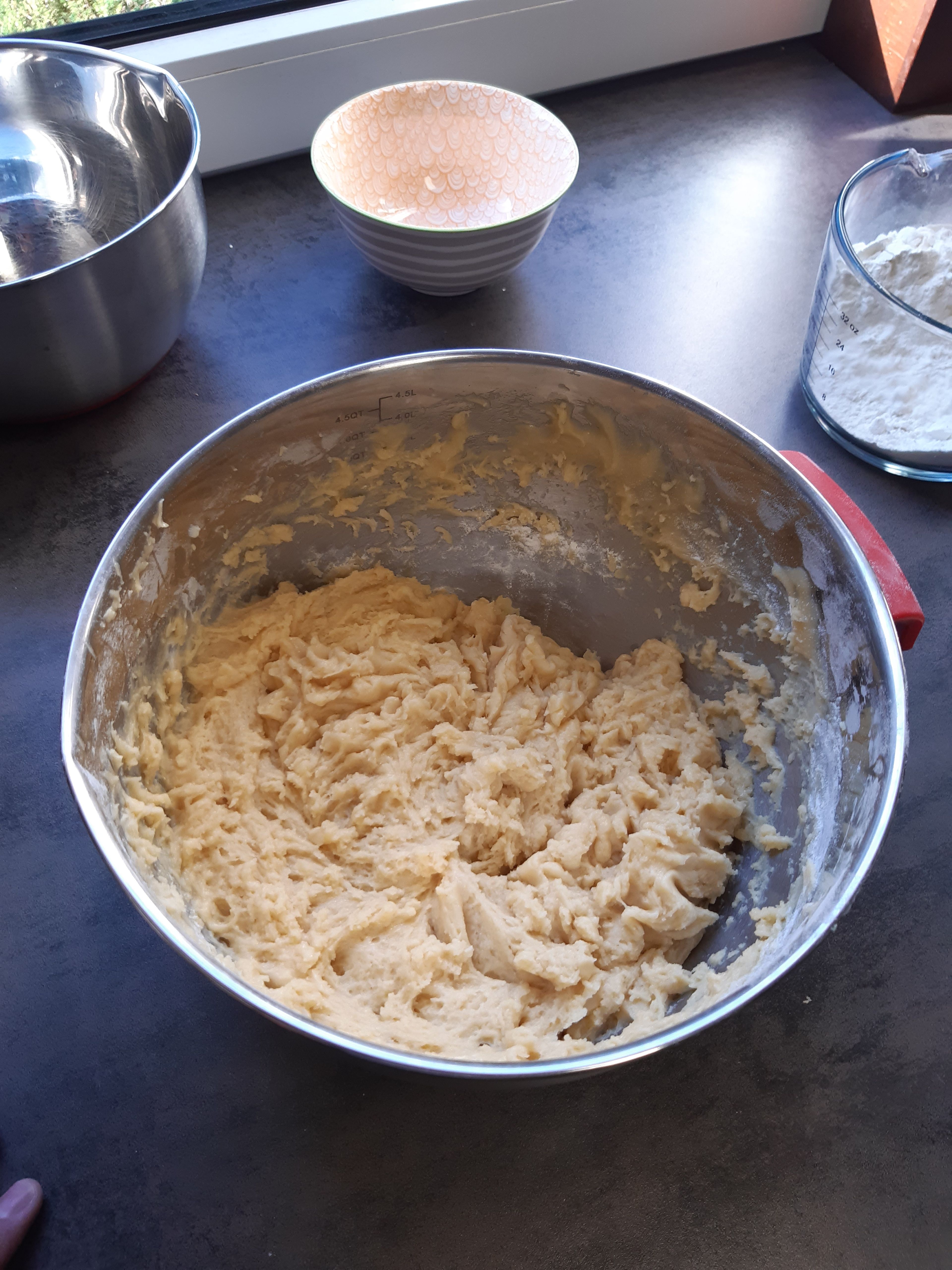 Butter in der Mikrowelle schmelzen und etwas abkühlen lassen.Das Eigelb schlagen und mit Schmand in einer großen Schüssel vermischen.   Geschmolzene Butter, Backpulver, Zucker und Salz hinzufügen. Alles gut vermischen, nun Mehl schrittweise hinzufügen und vorzugsweise mit einem elektrischen Rührgerät und Knethaken richtig kneten. Die Mengenangaben unbedingt beachten, auch wenn der Teig einem etwas zu weich vorkommt. Es wird im Kühlschrank etwas härter.