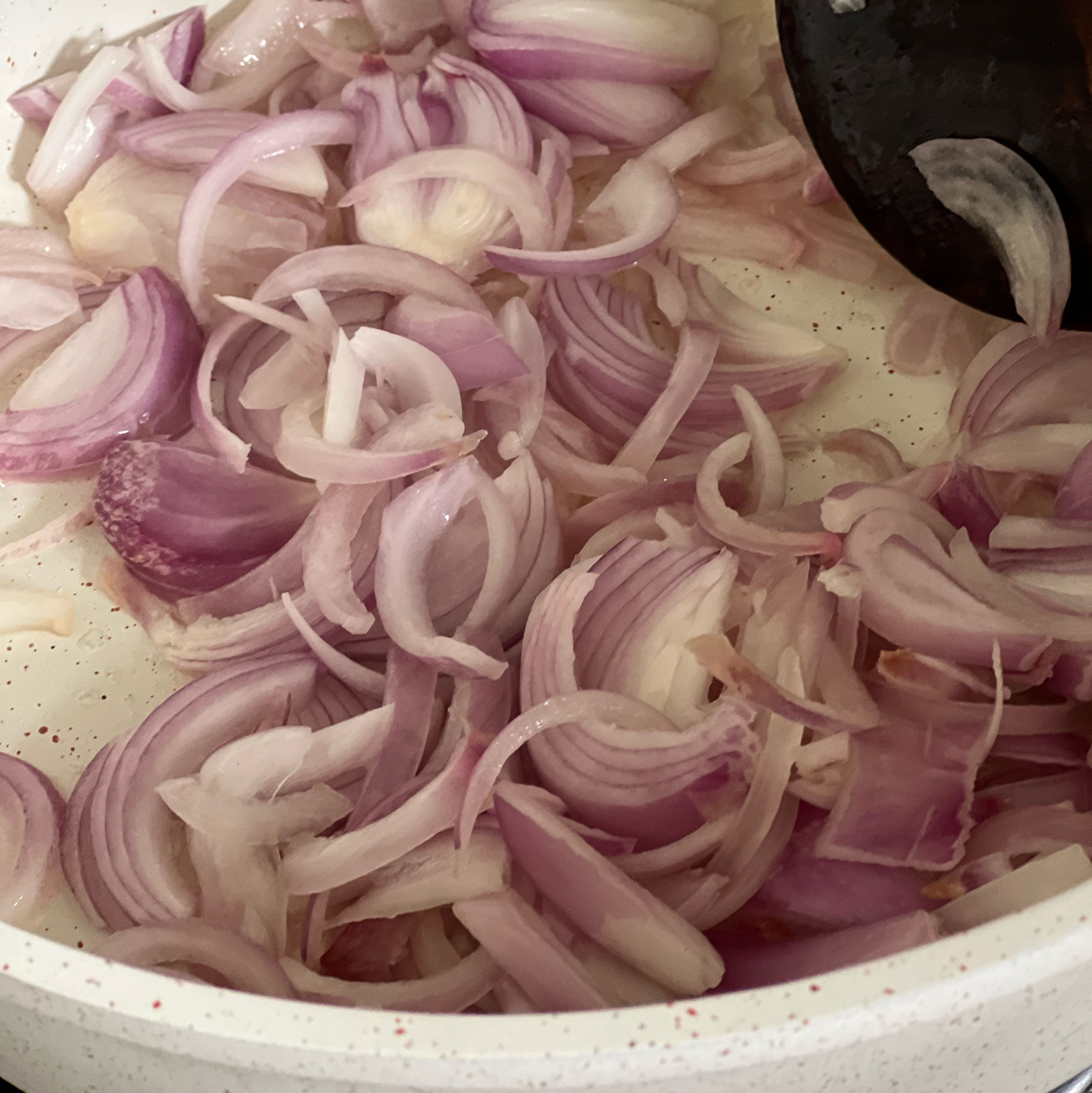 Add coconut oil in a heated tawa. Add the chopped onions and salt. Sauté it until the onions turn transparent.