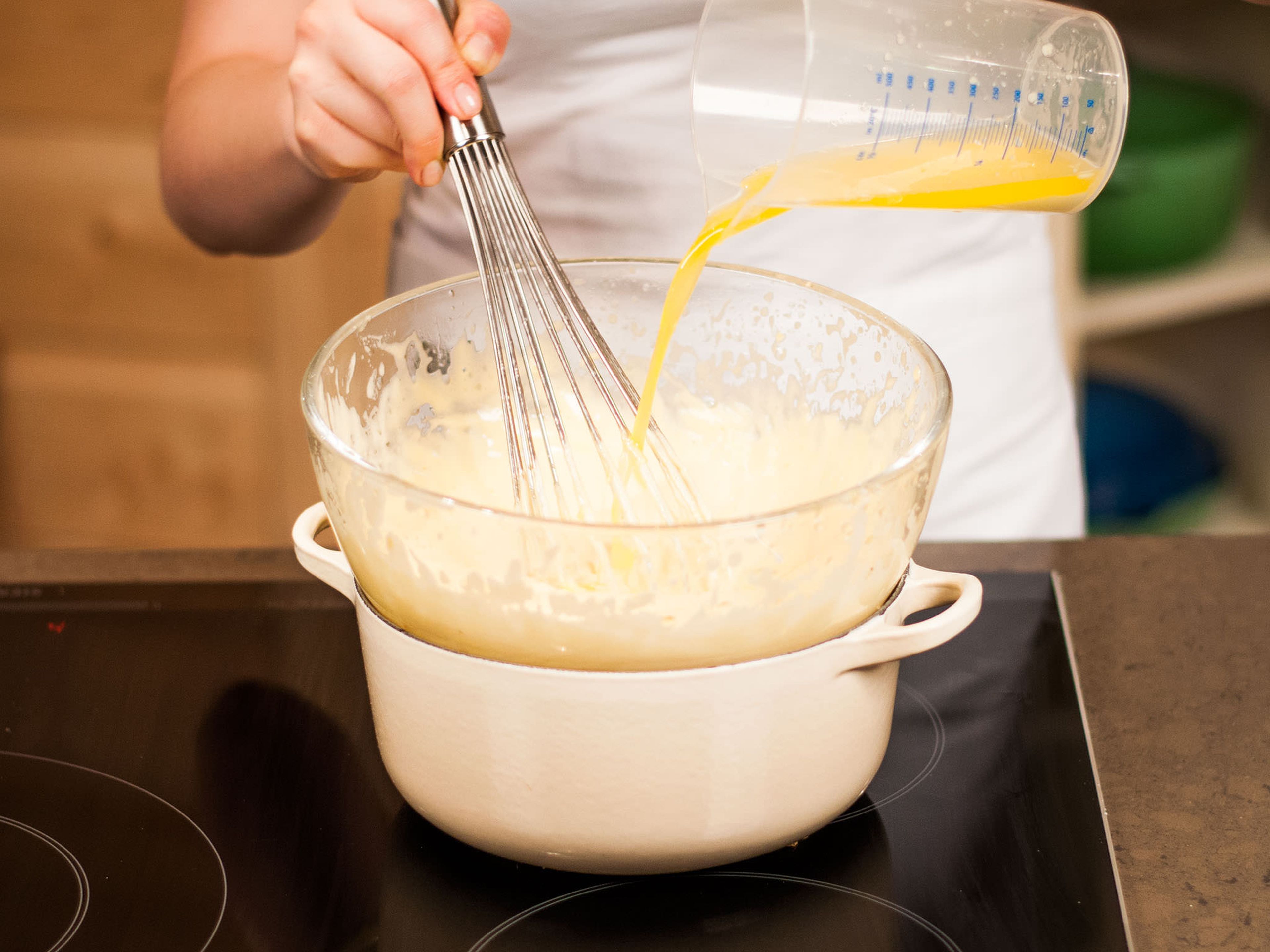 Jetzt langsam geschmolzene Butter in kleinen Portionen in die schaumige Masse gießen und konstant gut rühren. Mit Salz abschmecken und beiseitestellen.