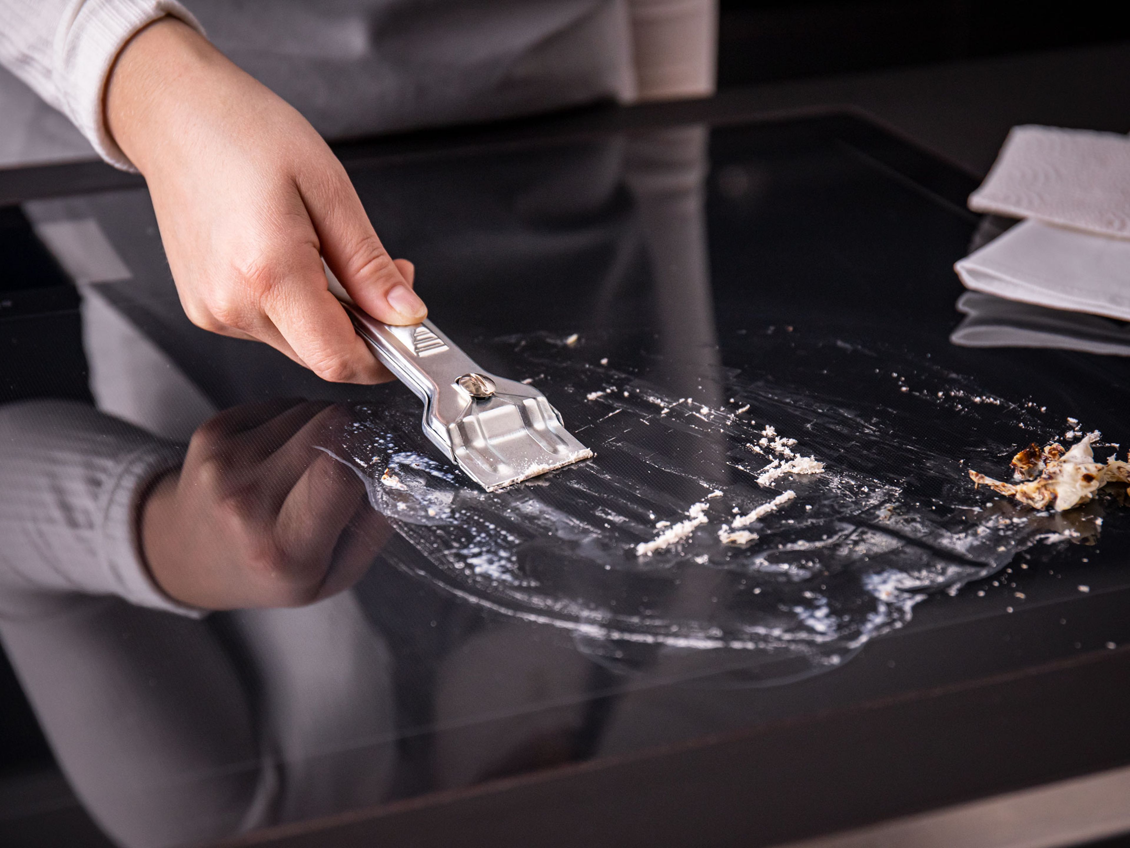 Minor cooking accidents can be solved with a simple cleaning routine. For difficult messes like burned milk or spilled pasta water, use a suitable metal scraper. Carefully scrape away the mess, then wipe any remaining residues from the cooktop.