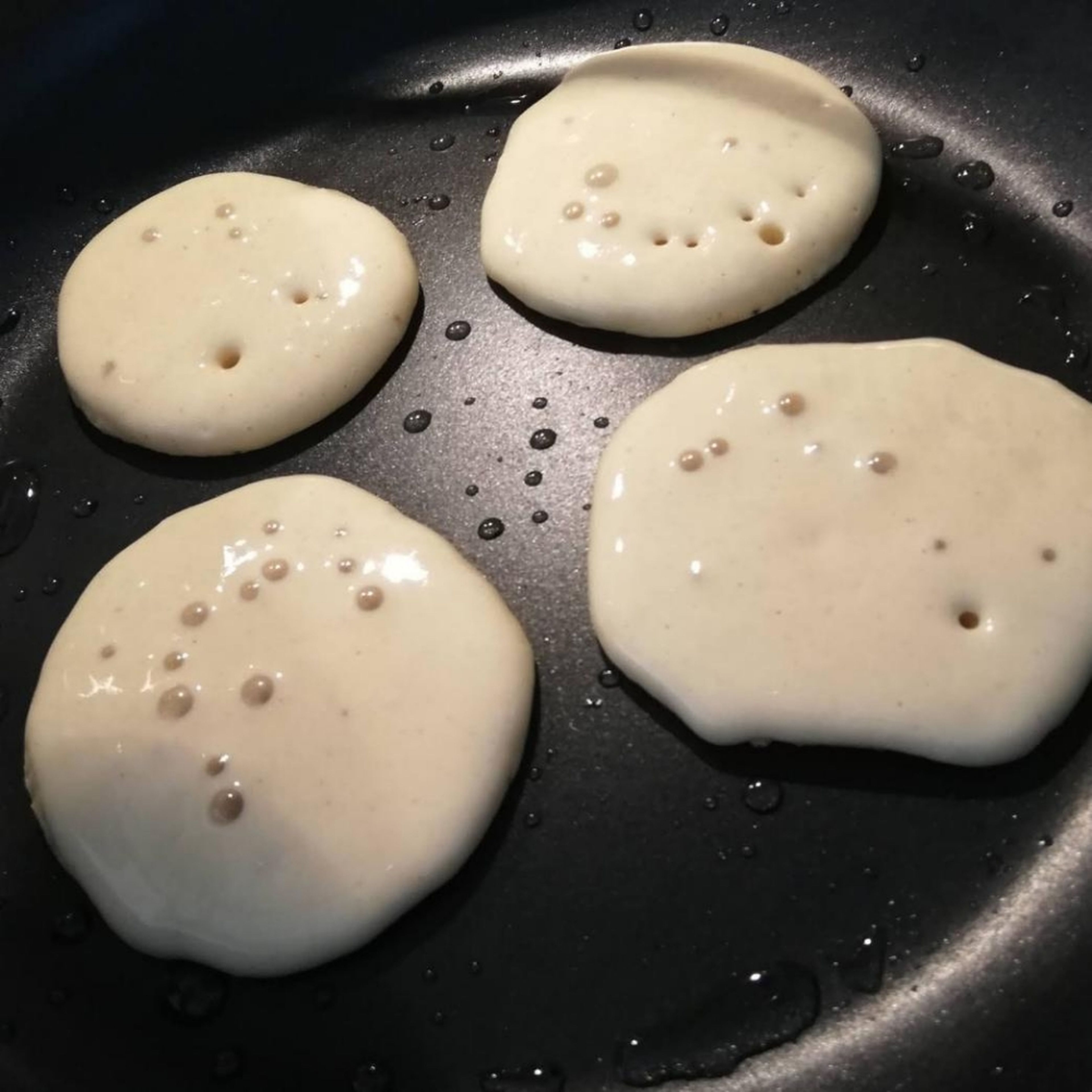 Pro Pancake eine kleine Saucenkelle Teig in die Pfanne geben, optional ein paar frische oder gefrorene Blaubeeren darauf verteilen, Deckel auf die Pfanne setzen und erst umdrehen, wenn kleine Blasen auf der Oberfläche platzen. Je nach Herd und Hitze sind die Pancakes pro Seite innerhalb einer halben Minute fertig.