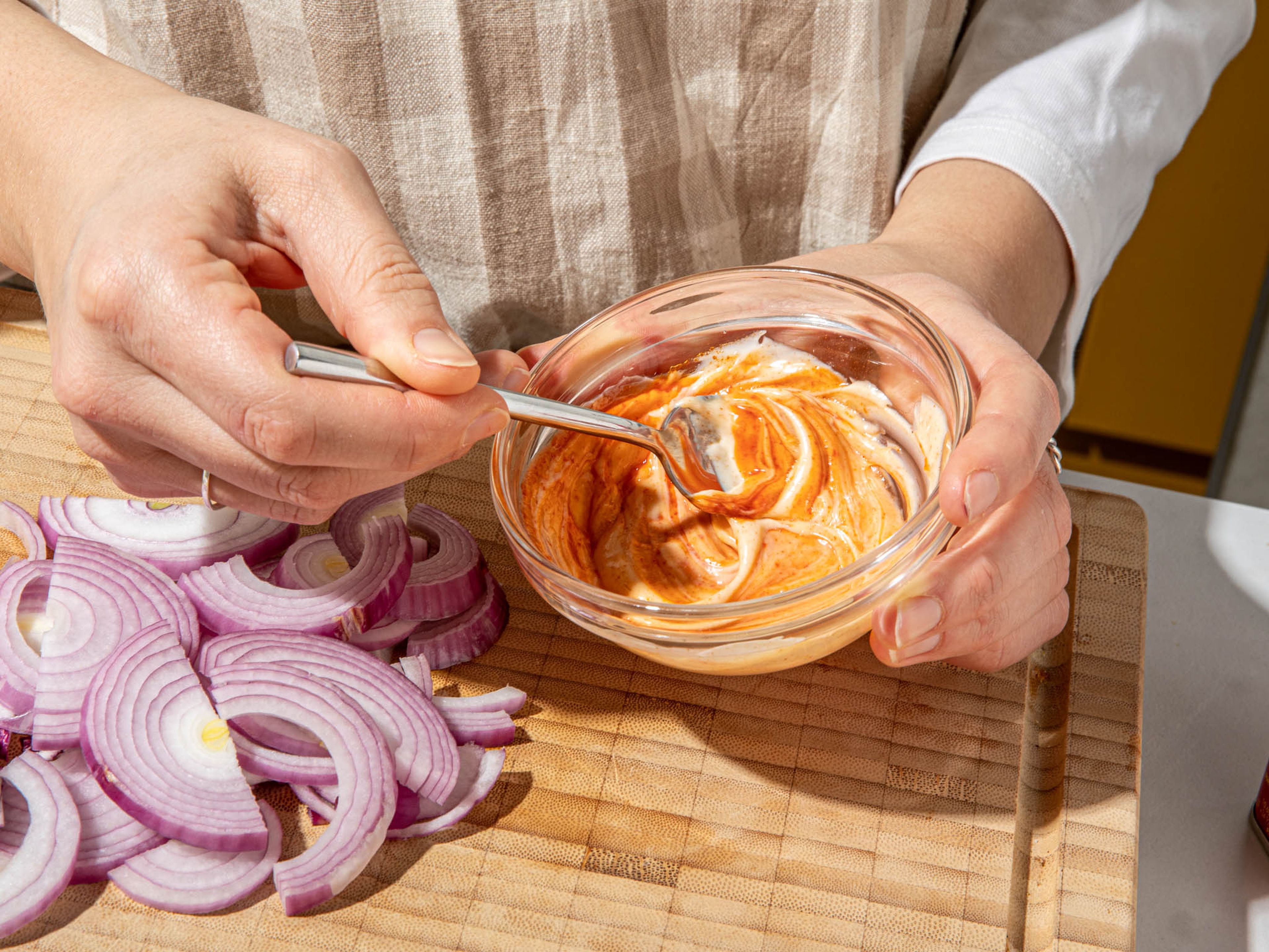Finely slice onion into rings. Melt butter in a small pot or frying pan over medium heat. Add onions and stir briefly. Season with salt, lower heat slightly and let cook until caramelized, for approx. 15 – 20 min. Meanwhile, in a small bowl, mix mayonnaise, smoky paprika powder, and sriracha and set aside.