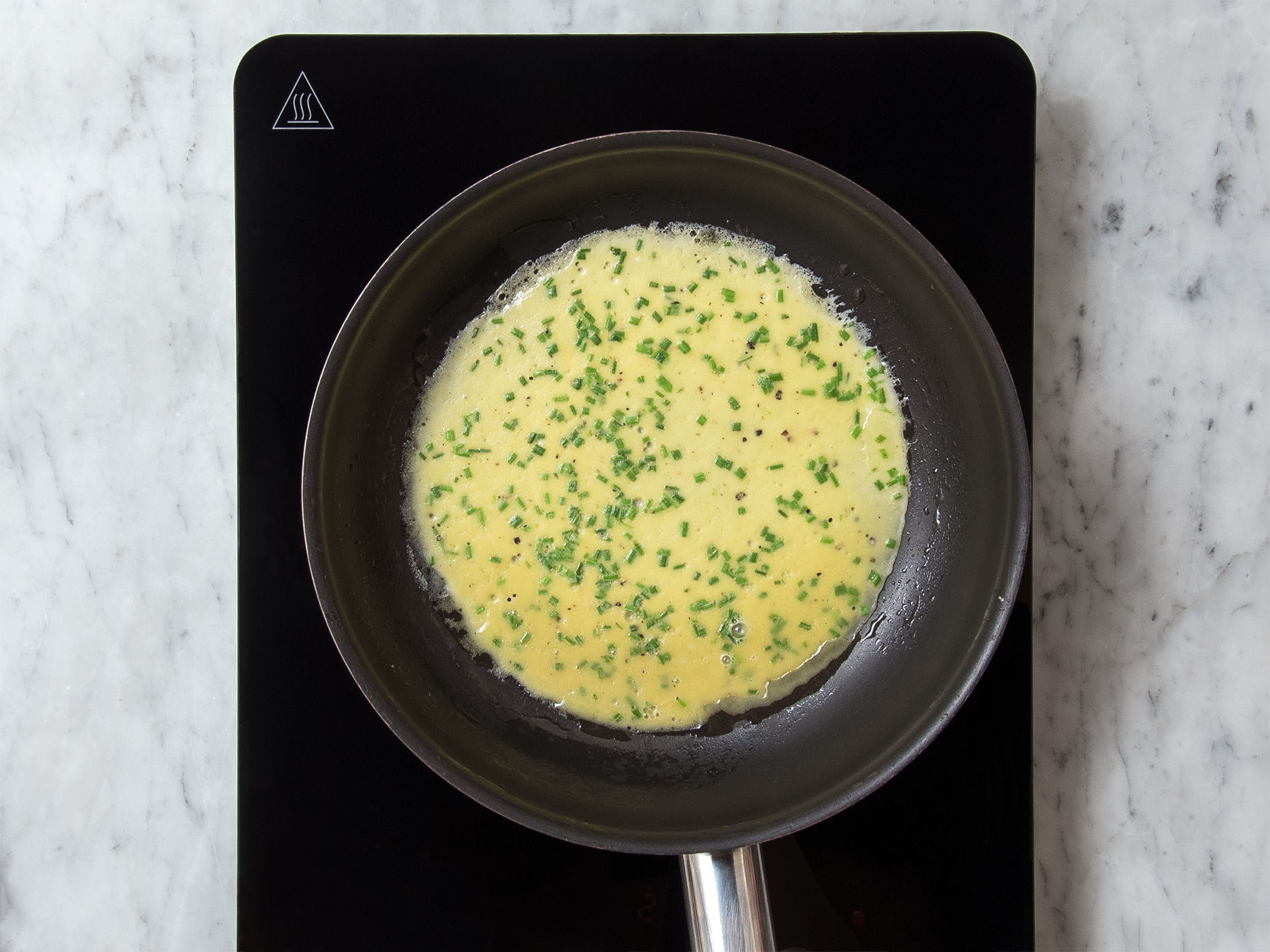 Pflanzenöl in einer beschichteten Pfanne über mittlerer Hitze erwärmen. Die Hälfte der Ei-Mischung in die Pfanne geben und ca. 2 - 3 Min. braten, bis die Eier durchgegart sind. Omelett wenden und von der anderen Seite ca. 1 Min. anbraten. Das Omelett aus der Pfanne nehmen und den Schritt mit der restlichen Ei-Mischung wiederholen.
