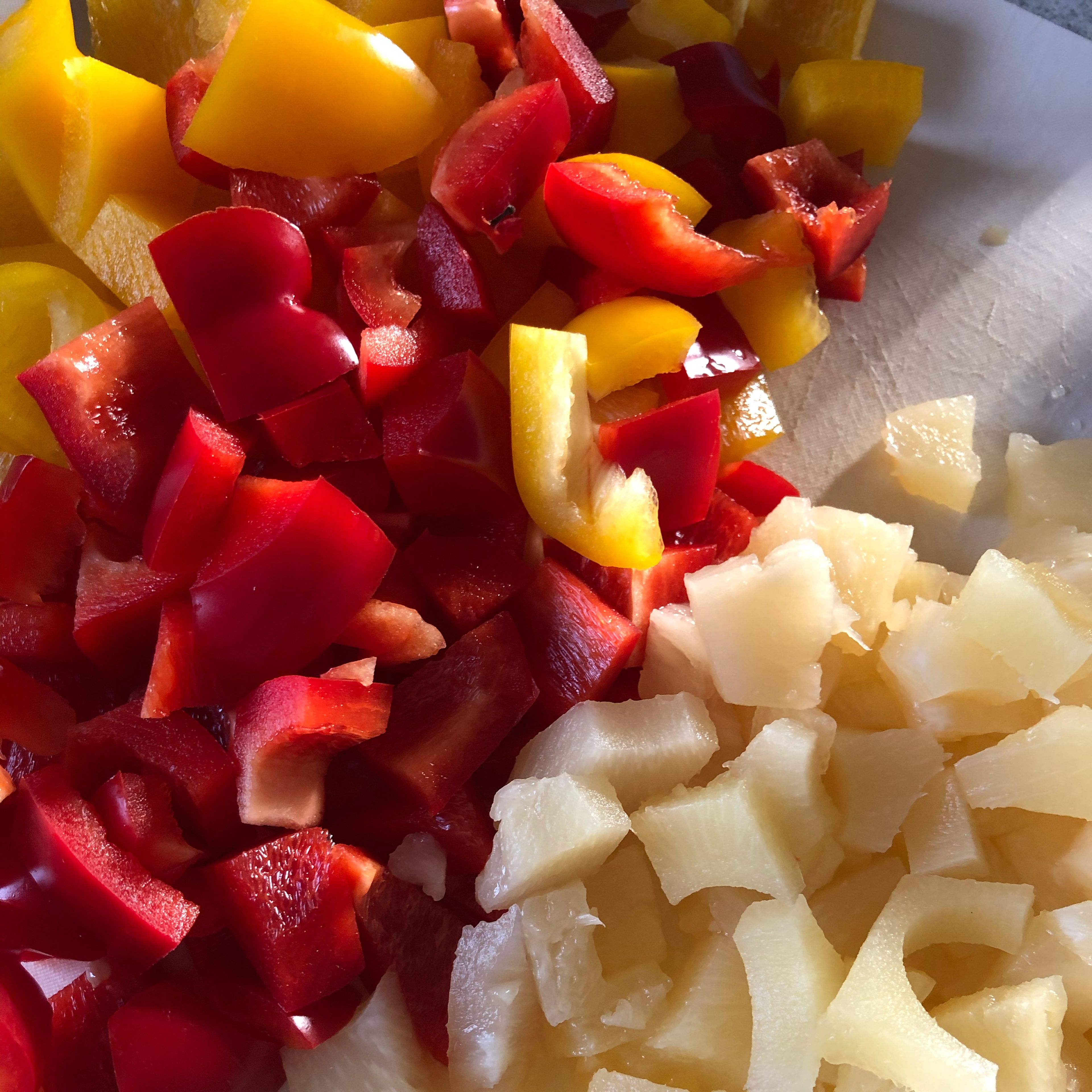 Paprika, Zwiebel und Ananas schneiden.