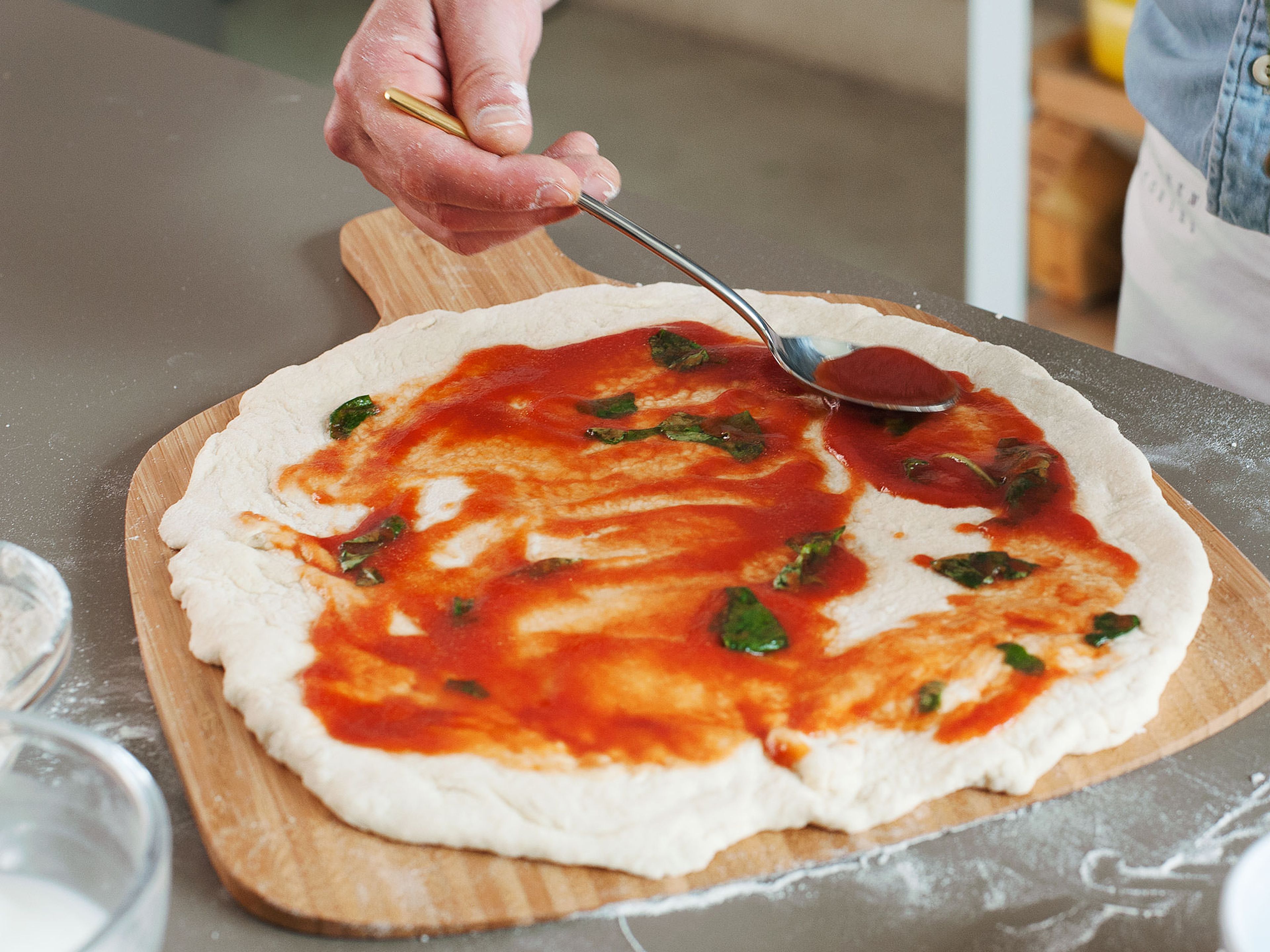 In einer kleinen Schüssel passierte Tomaten, Olivenöl und Salz mischen. Basilikumblätter grob abreißen und zur Sauce hinzugeben. Eine dünne Schicht der Sauce auf der Pizza verteilen und im vorgeheizten Backofen auf dem Pizzastein bei 250°C für ca. 6 - 7min. backen.