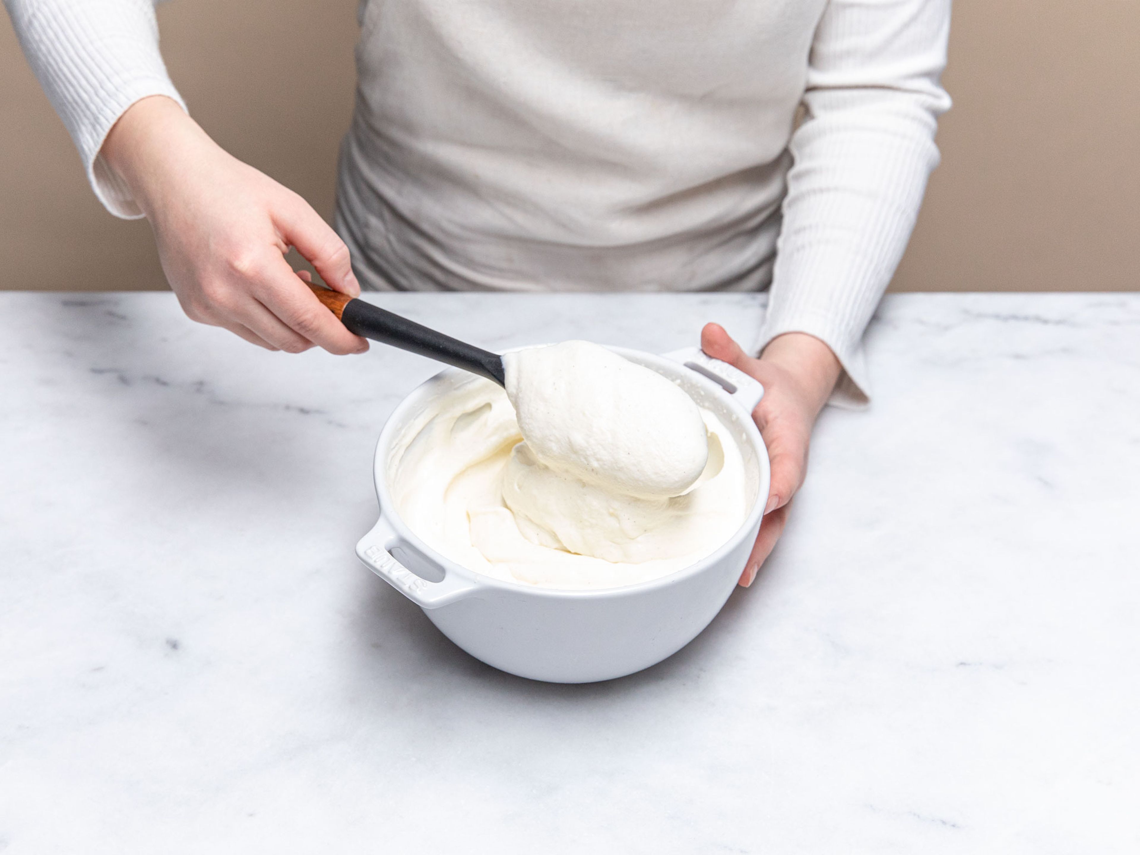 While baking, prepare whipped yogurt cream. In a bowl, whip cream with vanilla sugar, then fold in yogurt. Season with prepared lemon zest. Serve strawberry granola crisp with whipped yogurt cream. Enjoy!