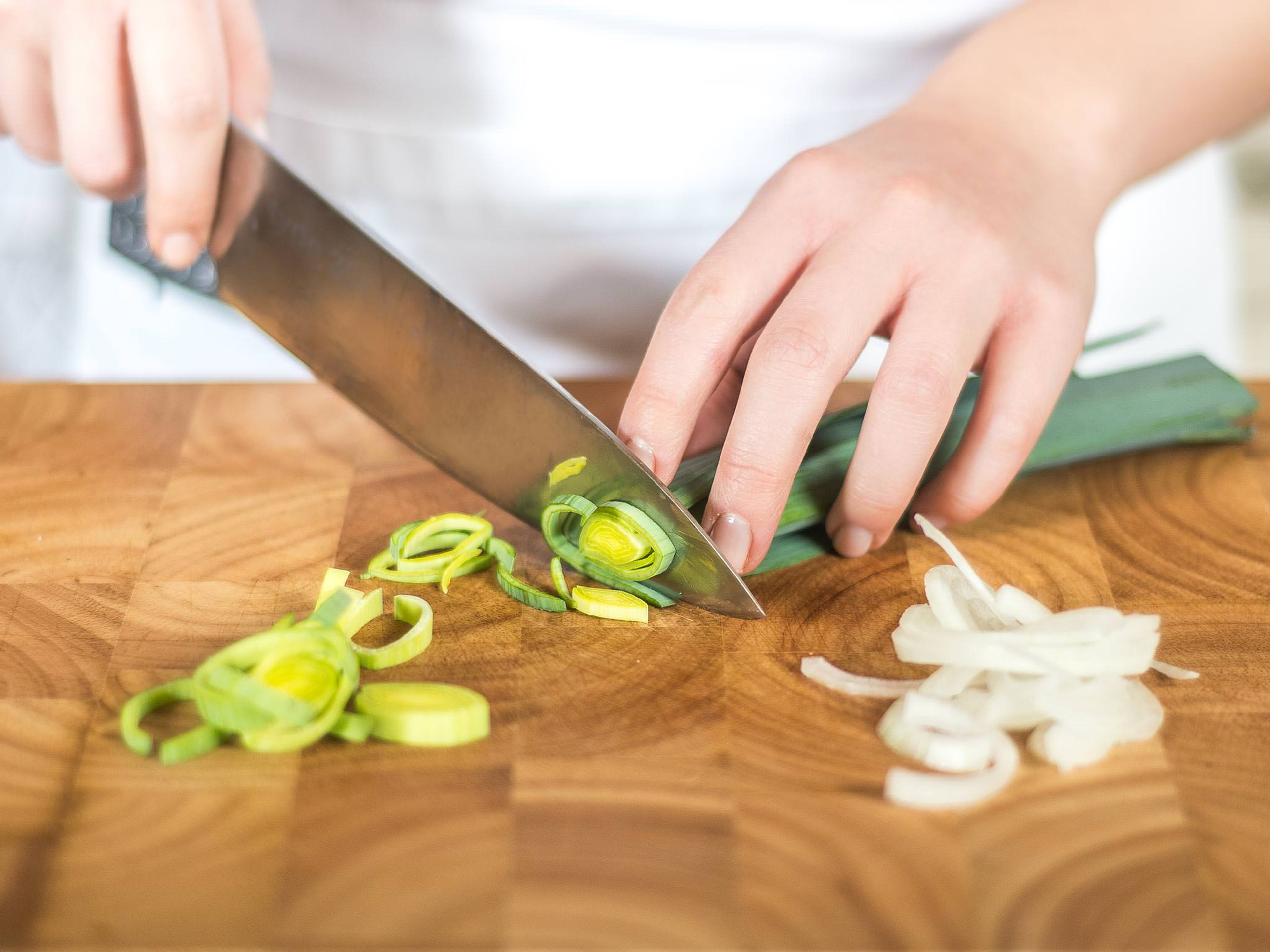 Für Lachs mit Gemüse aus der Heißluftfritteuse zuerst Paprika, Zucchini und Aubergine in kleine Würfel schneiden. Zwiebel und Lauch in feine Ringe schneiden.