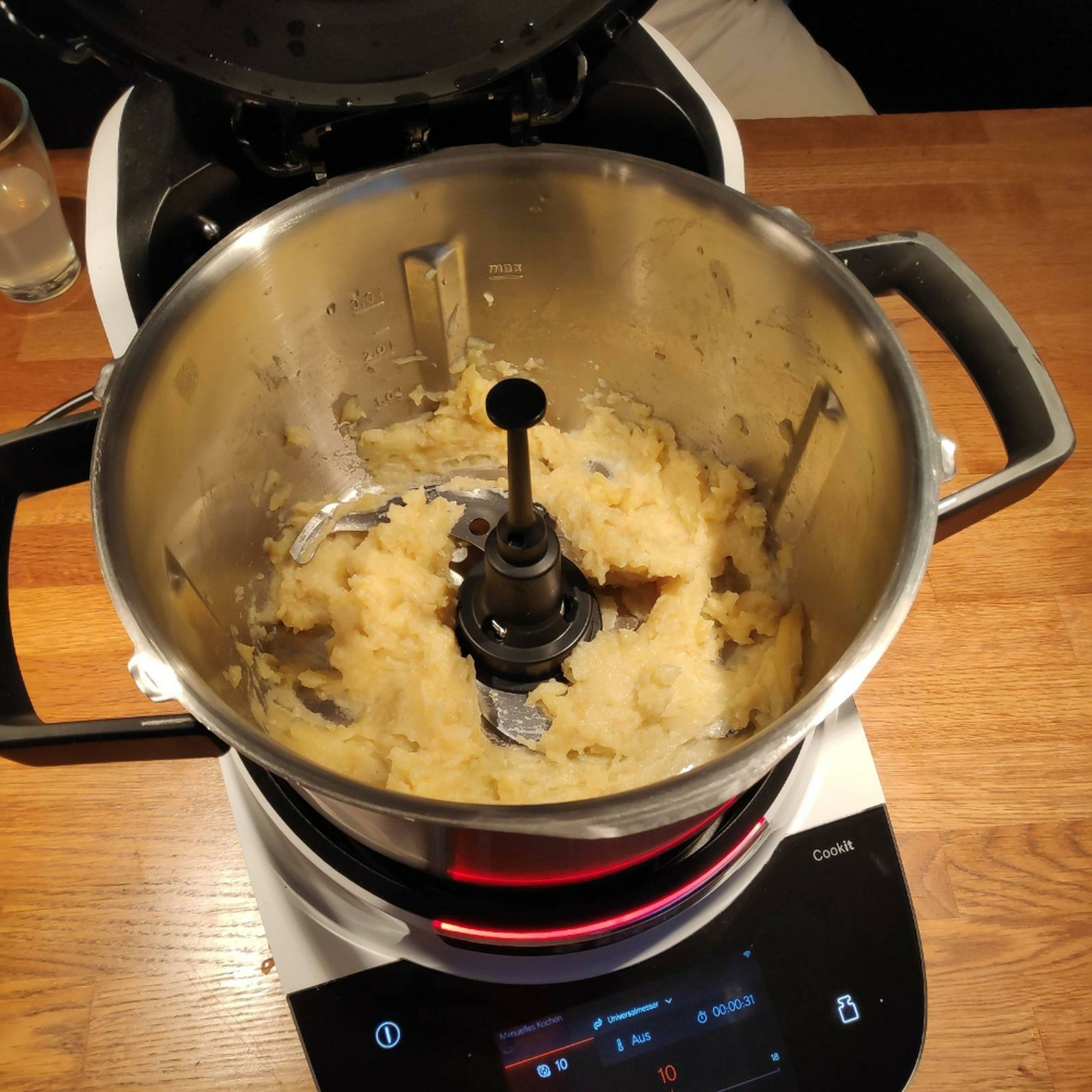 Universalmesser wieder einsetzen. Die Kartoffeln schälen und mit ausreichend Wasser im Kartoffelkochprogramm des Cookits weich kochen. Anschließend das Wasser abgießen. Nun die gekochten Kartoffeln im manuellen Kochmodus mit dem Universalmesser bei Stufe 10 für ca. 15 Sekunden bei geschlossenem Deckel mit Messbecher zerkleinern, sodass noch Stücke der Kartoffel erhalten bleiben (kein Püree) (Universalmesser | Stufe 10 | 15 Sek.).
Universalmesser entnehmen und die zerkleinerten Kartoffeln mit Hilfe des Küchenspatels in eine Schüssel umfüllen.