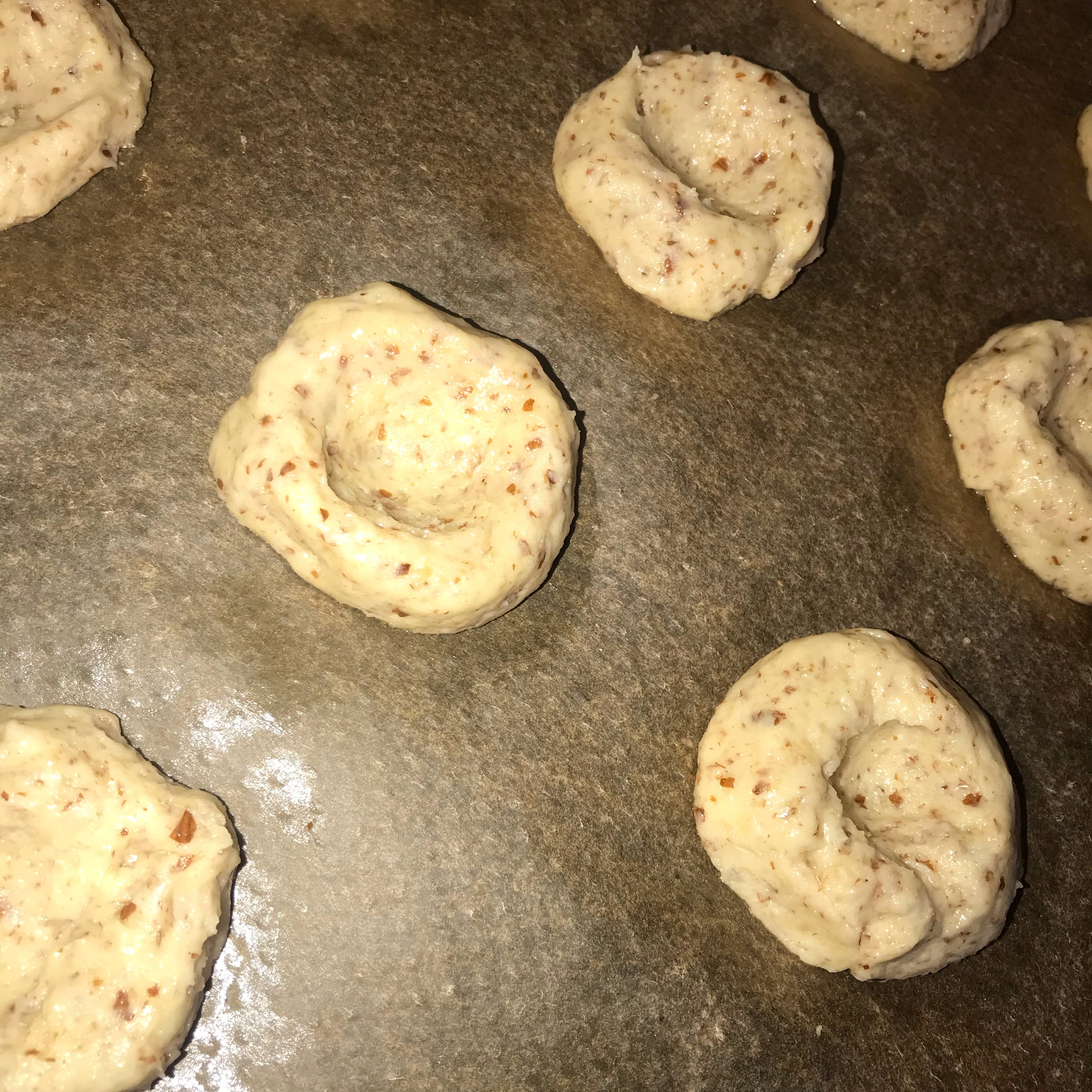 Preheat oven to 180°C/350°F. Form the dough into walnut-sized balls and place them on a lined baking sheet.  Flatten them slightly and use the handle of a spoon to make small indentations in the middle.
