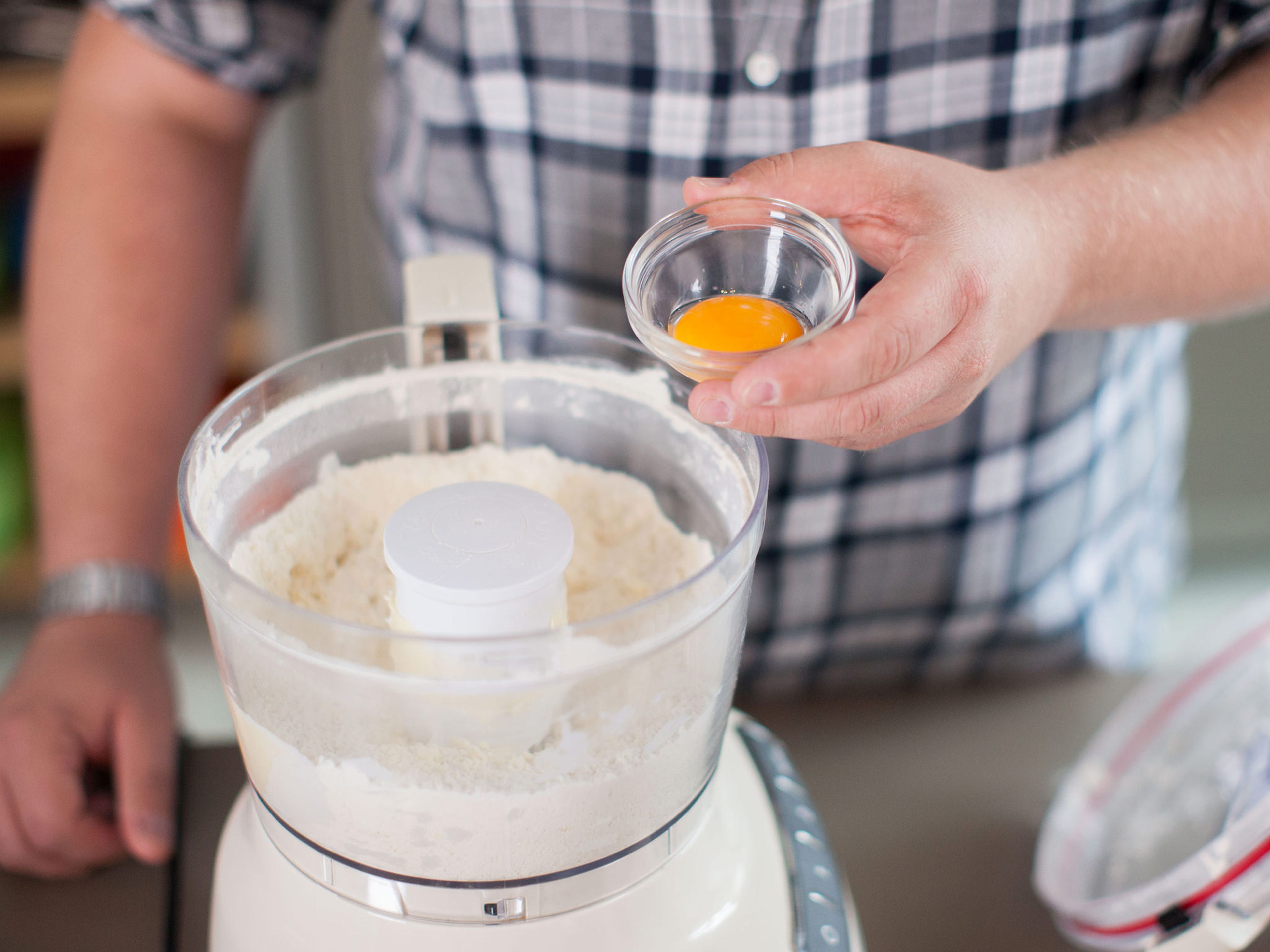 Add flour, butter, and confectioner’s sugar to a food processor and pulse briefly. Separate a part of the eggs and add yolk as well as cold water to the food processor. Pulse until dough comes together. Wrap in plastic wrap and let rest in the refrigerator for approx. 15 min.