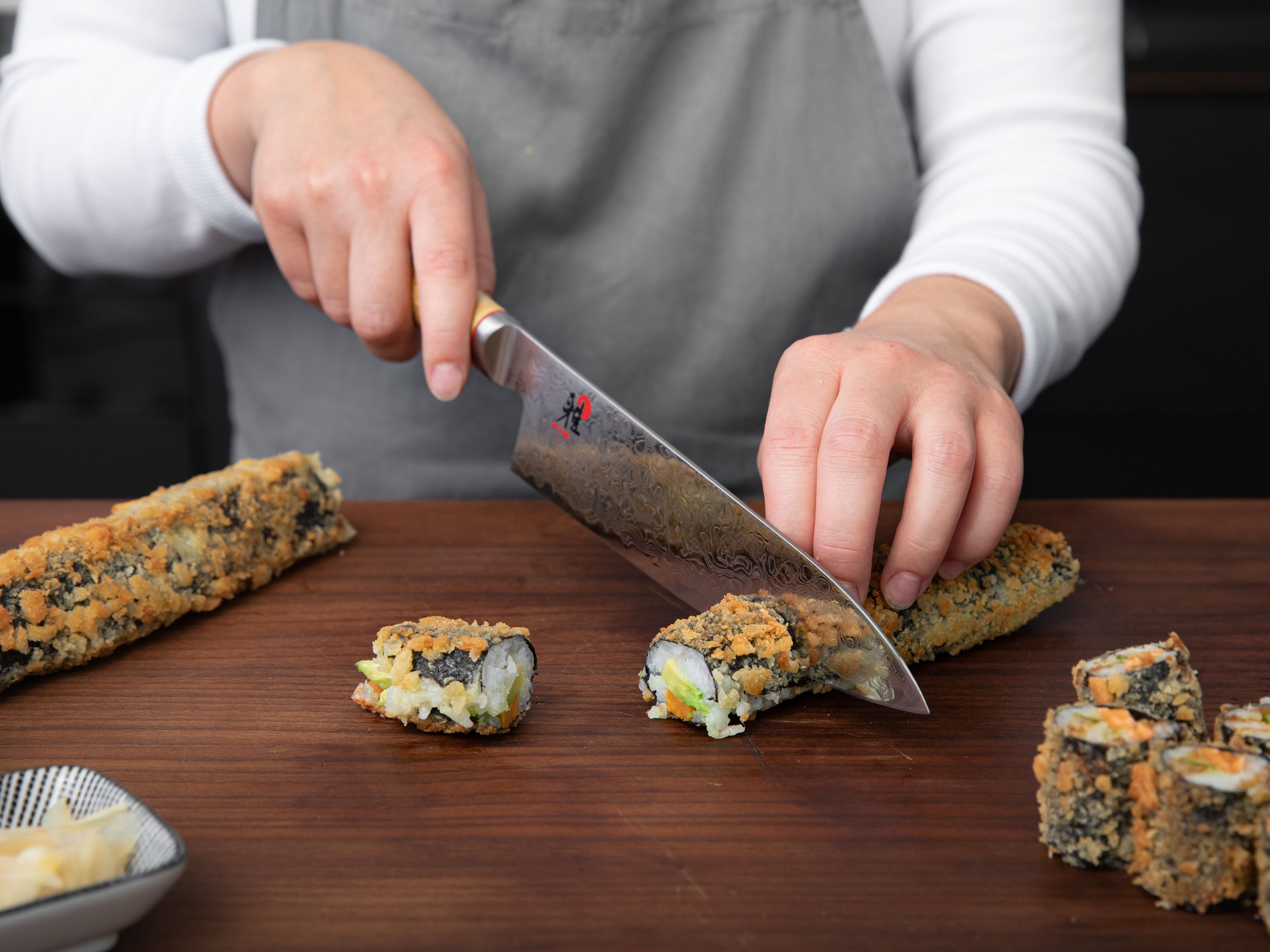 Die frittierten Sushirollen in gleich große Stücke schneiden und mit Nitsume-Soße beträufeln. Mit Sushi-Ingwer, Sojasauce und Wasabi servieren. Guten Appetit!
