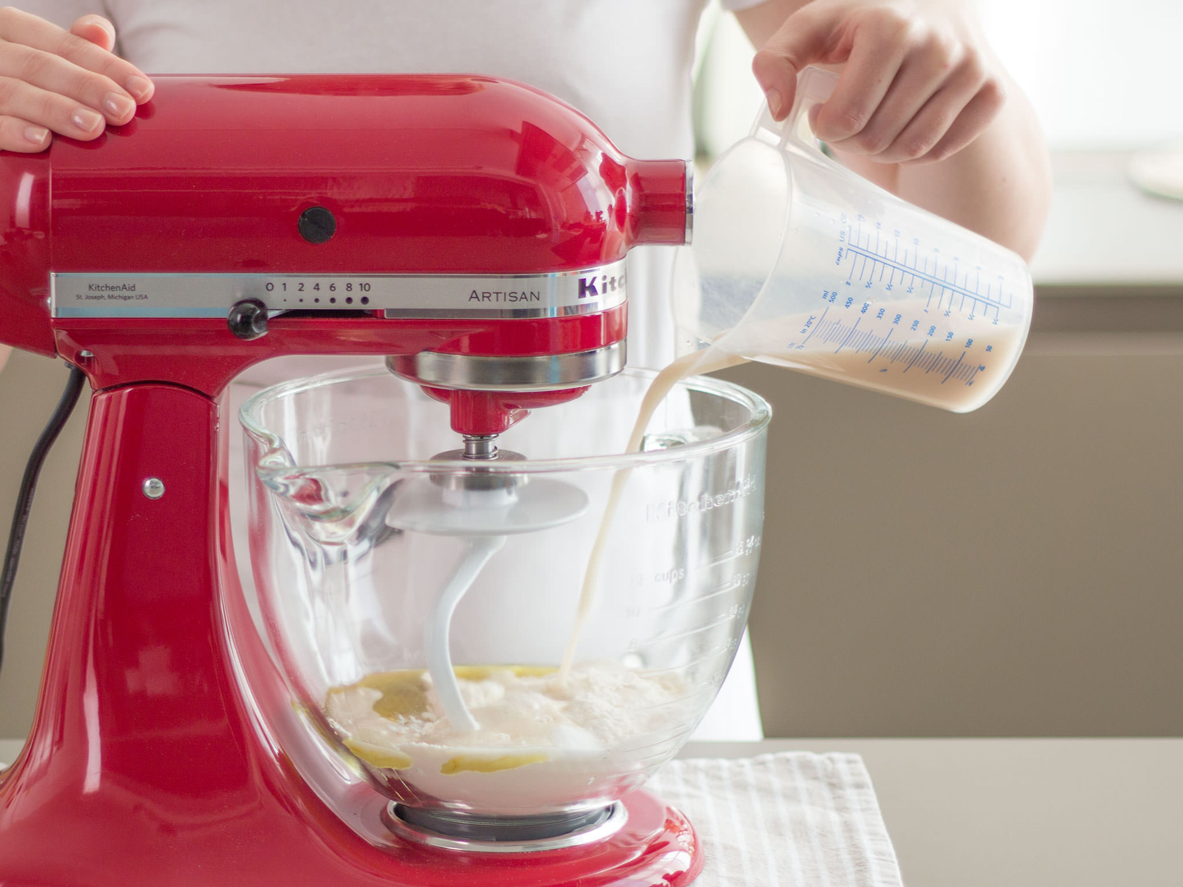 Dissolve yeast and sugar in lukewarm water and let sit for approx. 15 to 20 minutes, or until mixture is foamy. Sift flour into standing mixer. Pour yeast and sugar into standing mixer.