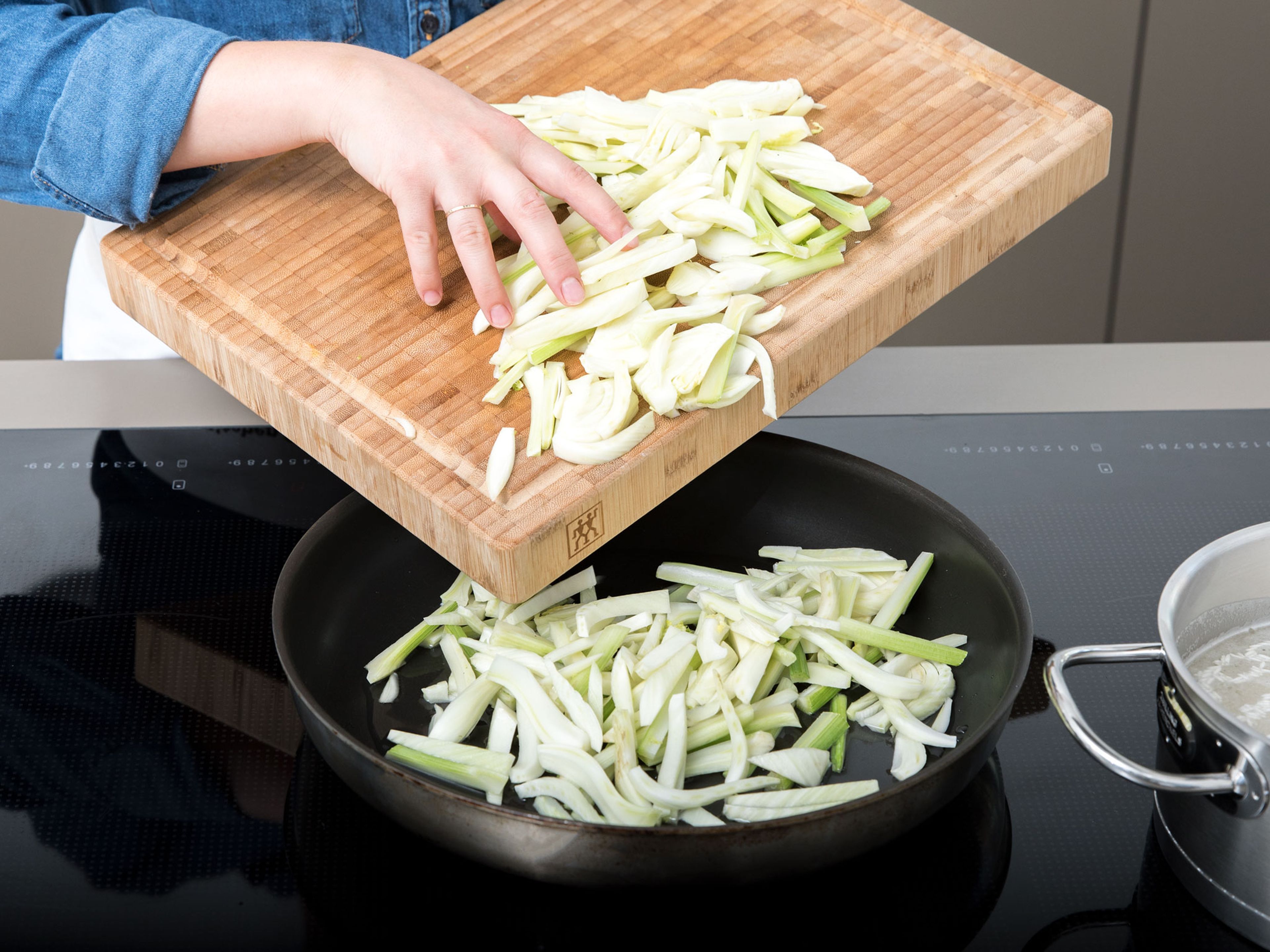 Add fennel and water to a large frying pan, cover with a lid and steam until the fennel is softened. Remove fennel from the pan and transfer to a large bowl.
