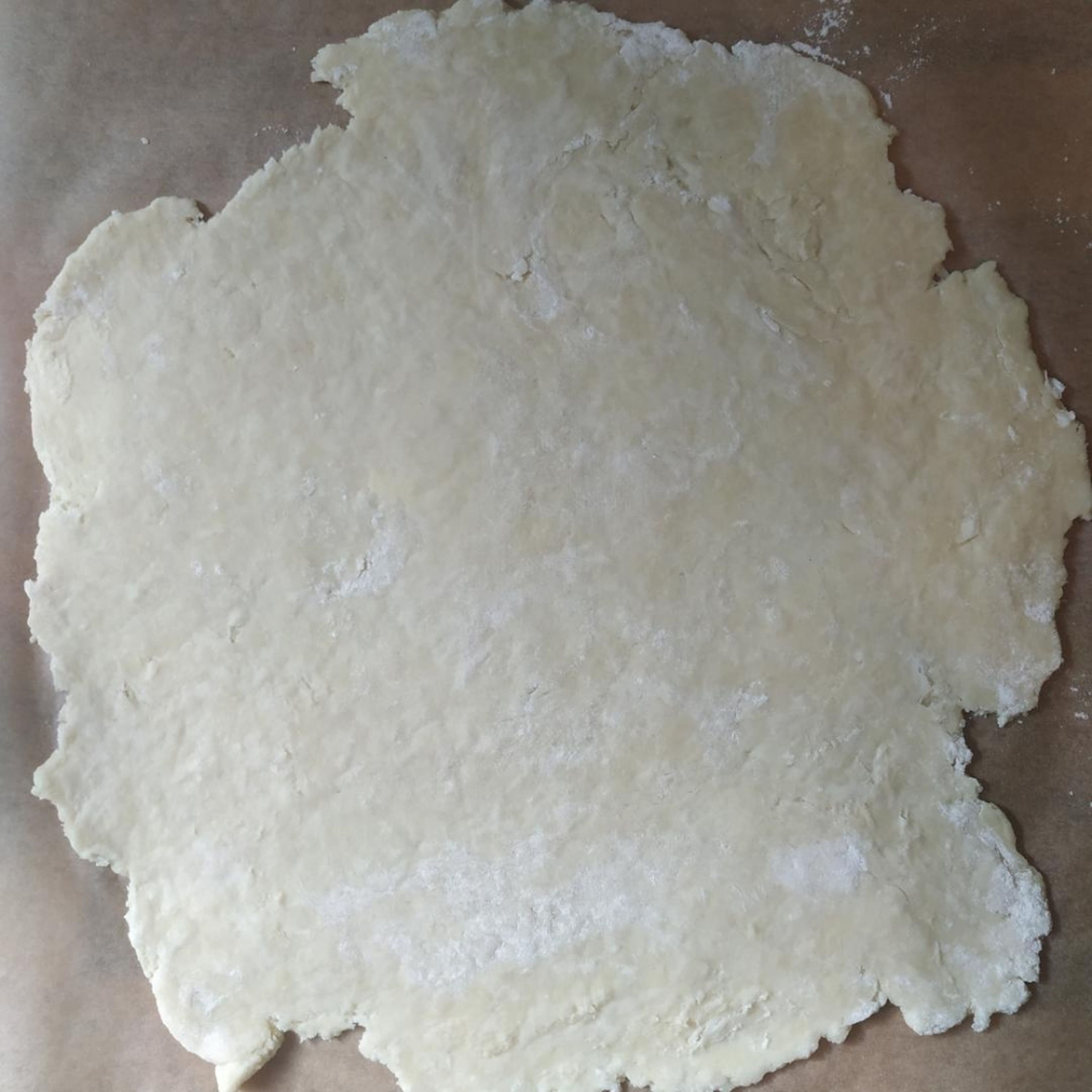 Den Teig auf einer bemehleten Arbeitsfläche ausrollen. Da die Crostata gefaltet wird, muss er nicht super akkurat rund sein. Der Teig sollte ca 1/2 cm dick sein, sodass er auf ein Backblech passt.