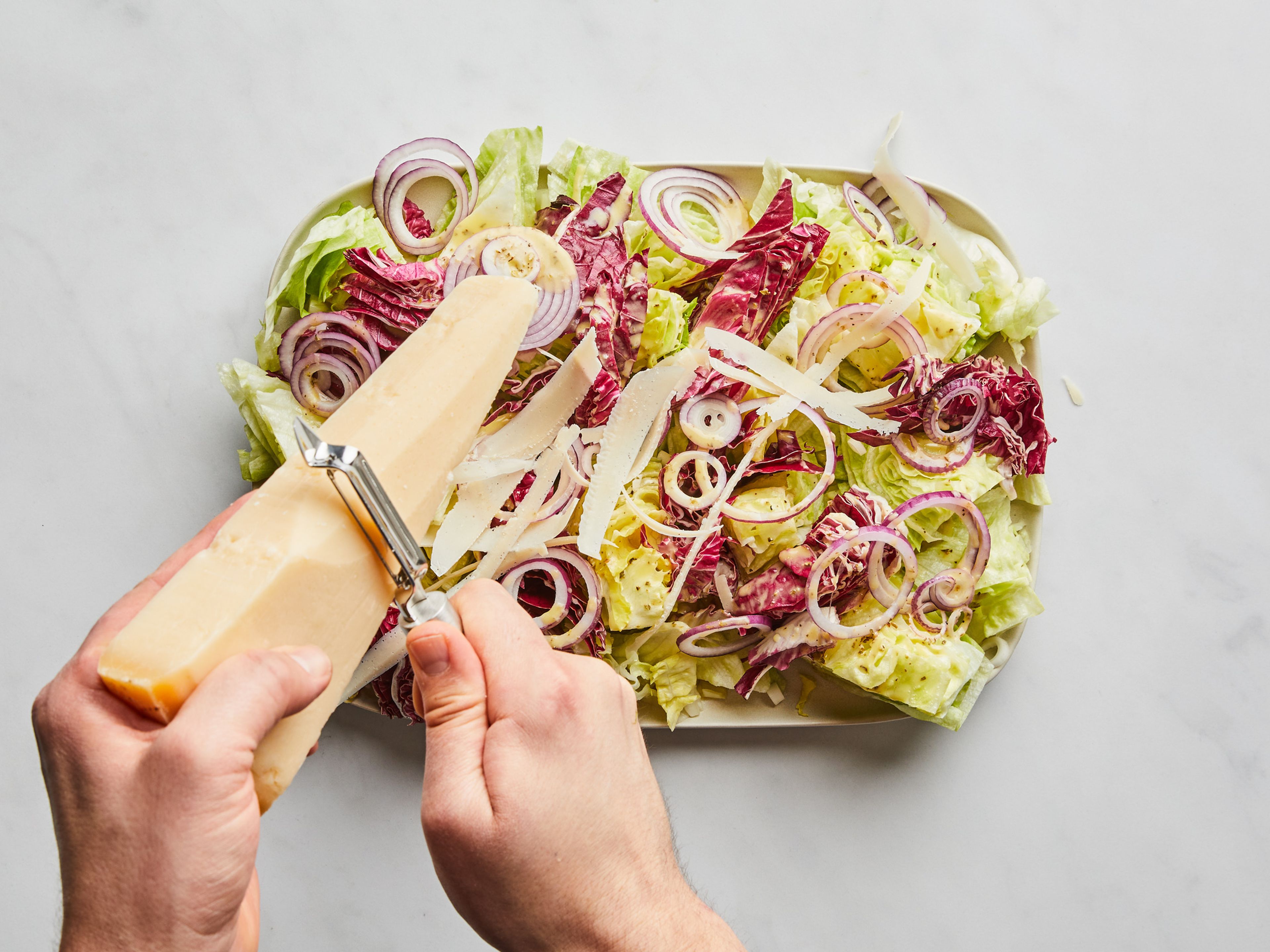 To serve, pour dressing over the serving platter. Use a vegetable peeler to shave Parmesan cheese over the top, and finish with freshly ground black pepper. Enjoy!