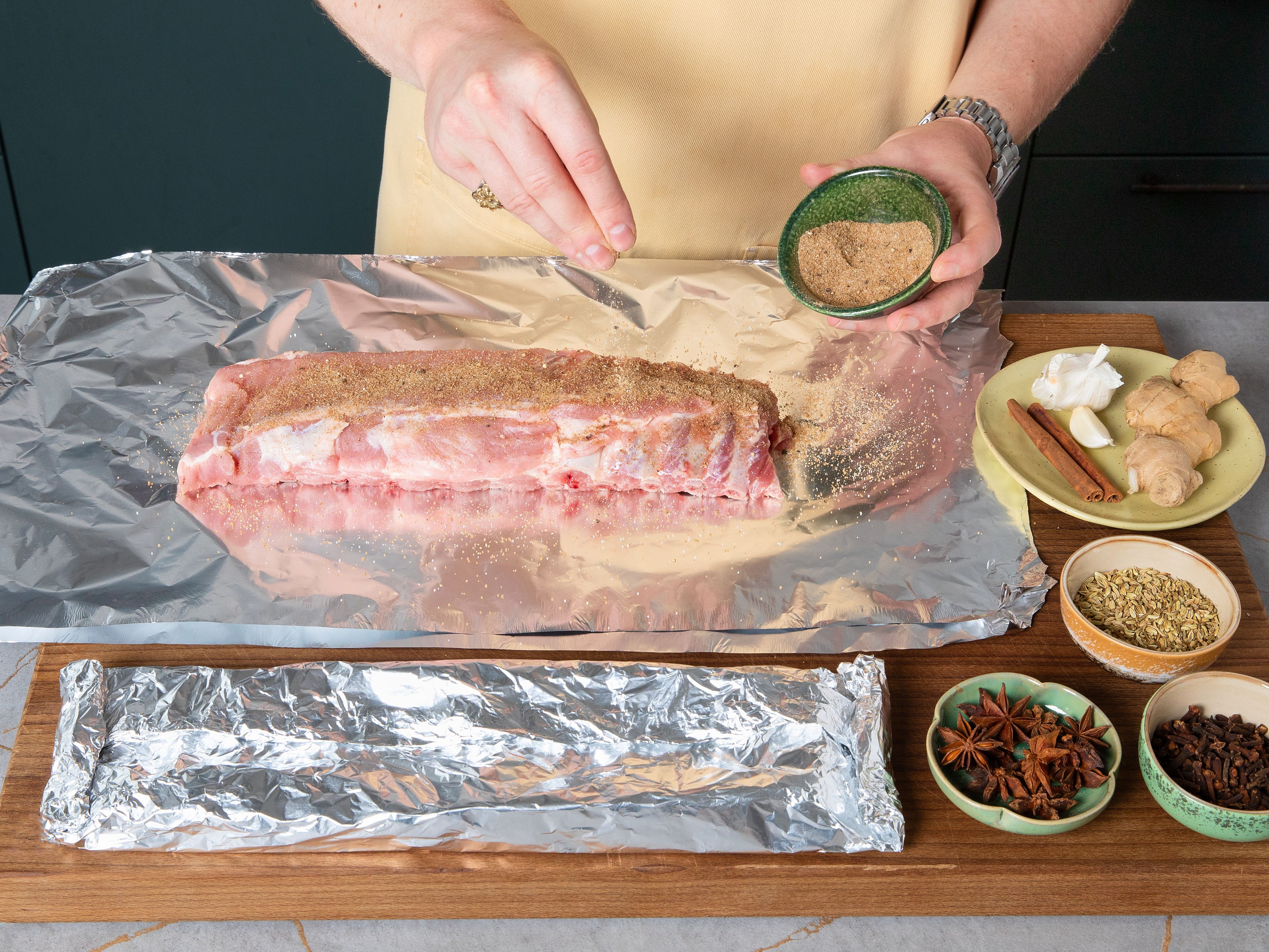 Preheat oven to 120°C/248°F top/bottom heat. For the dry rub, mix together a third of the brown sugar, salt, garlic powder, five spice, white pepper, and black pepper in a small bowl. Take a piece of aluminium foil more than twice the length of the rack of ribs and fold in half to create a double-layered piece. Place ribs on top of foil and peel off the thin membrane (silverskin) on the back of the ribs. Sprinkle dry rub over both sides of ribs, but mostly on top of the meaty side. Flip ribs so the meaty side is facing downwards on the foil. Fold foil together over ribs, crimping and rolling to form an airtight package with seam at top. Place th foil package on baking-paper-lined tray and bake for approx. 2 hrs. in the preheated oven.