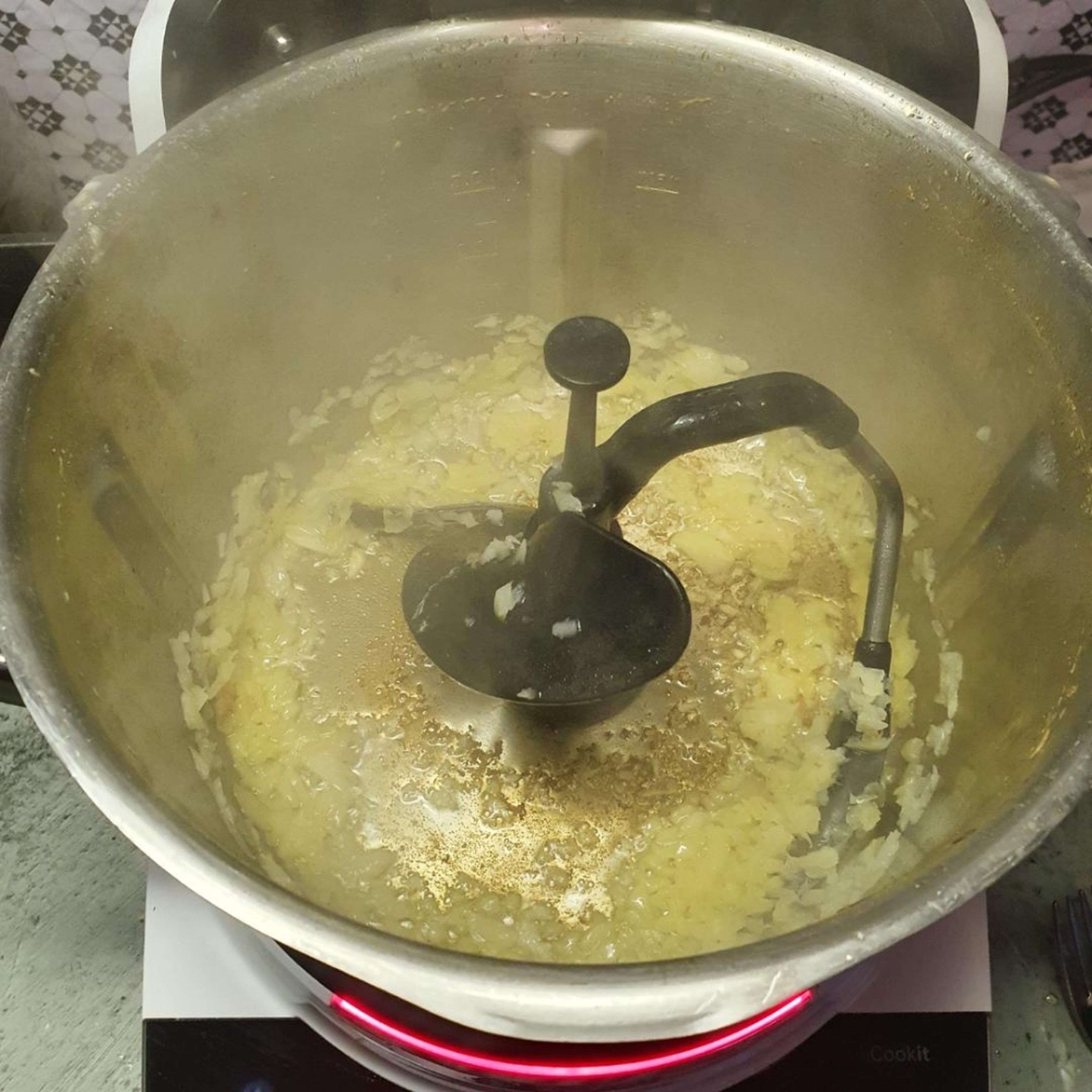 3D-Rührer einsetzen, Olivenöl in den Topf einwiegen, Deckel ohne Messbecher schließen und erhitzen (3D-Rührer | Stufe 5 | 130°C | 1 Minute). Sobald das Öl heiß ist, die beiseite gestellte, klein geschnittene Zwiebel zugeben, Deckel ohne Messbecher schließen und andünsten (3D-Rührer | Stufe 5 | 130°C | 2 Minuten).