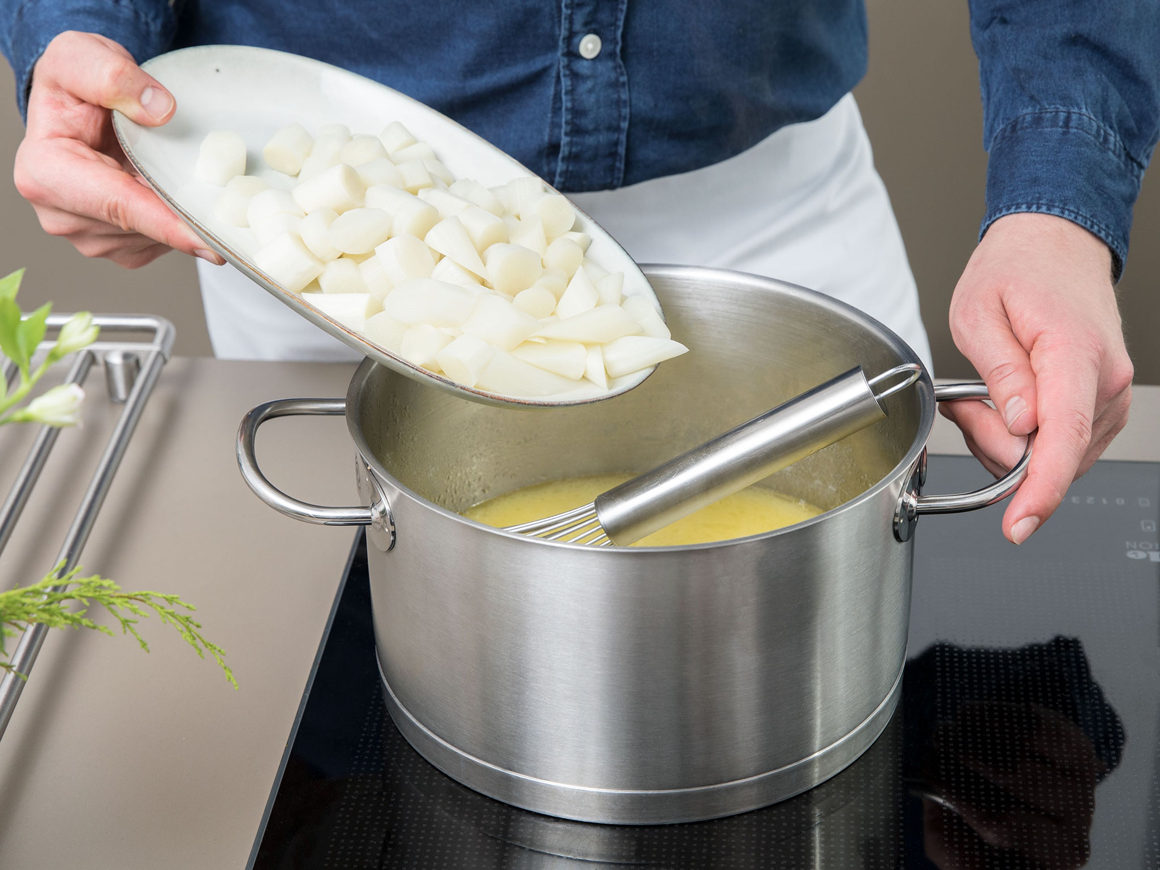 Butter in einem Topf schmelzen und Zwiebelwürfel dazugeben. Bei kleiner bis mittlerer Hitze ca. 1 Min. anschwitzen. Mehl einrühren und mit Weißwein und Spargel-Kochflüssigkeit ablöschen. Klein geschnittene Spargelstangen in den Topf geben und Sahne einrühren. Die Suppe ca. 10 Min. köcheln lassen und mit weißem Pfeffer und Salz  abschmecken.