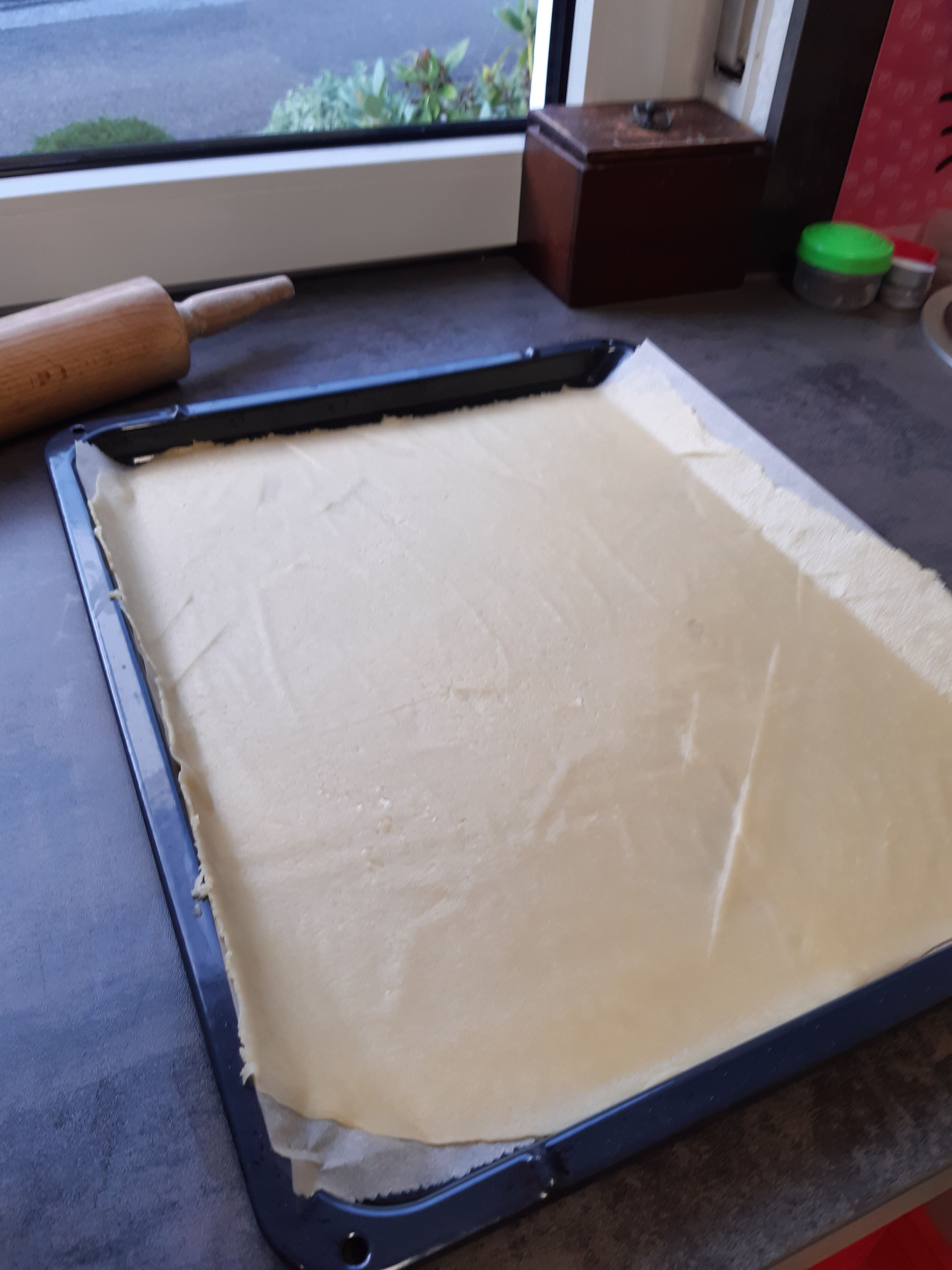 Den Teig aus dem Kühlschrank nehmen, die erste Kugel auf dem Backpapier ausrollen, etwa 1-2mm, damit das ganze Blech bedeckt ist. Aufs Blech mit Papier legen. 