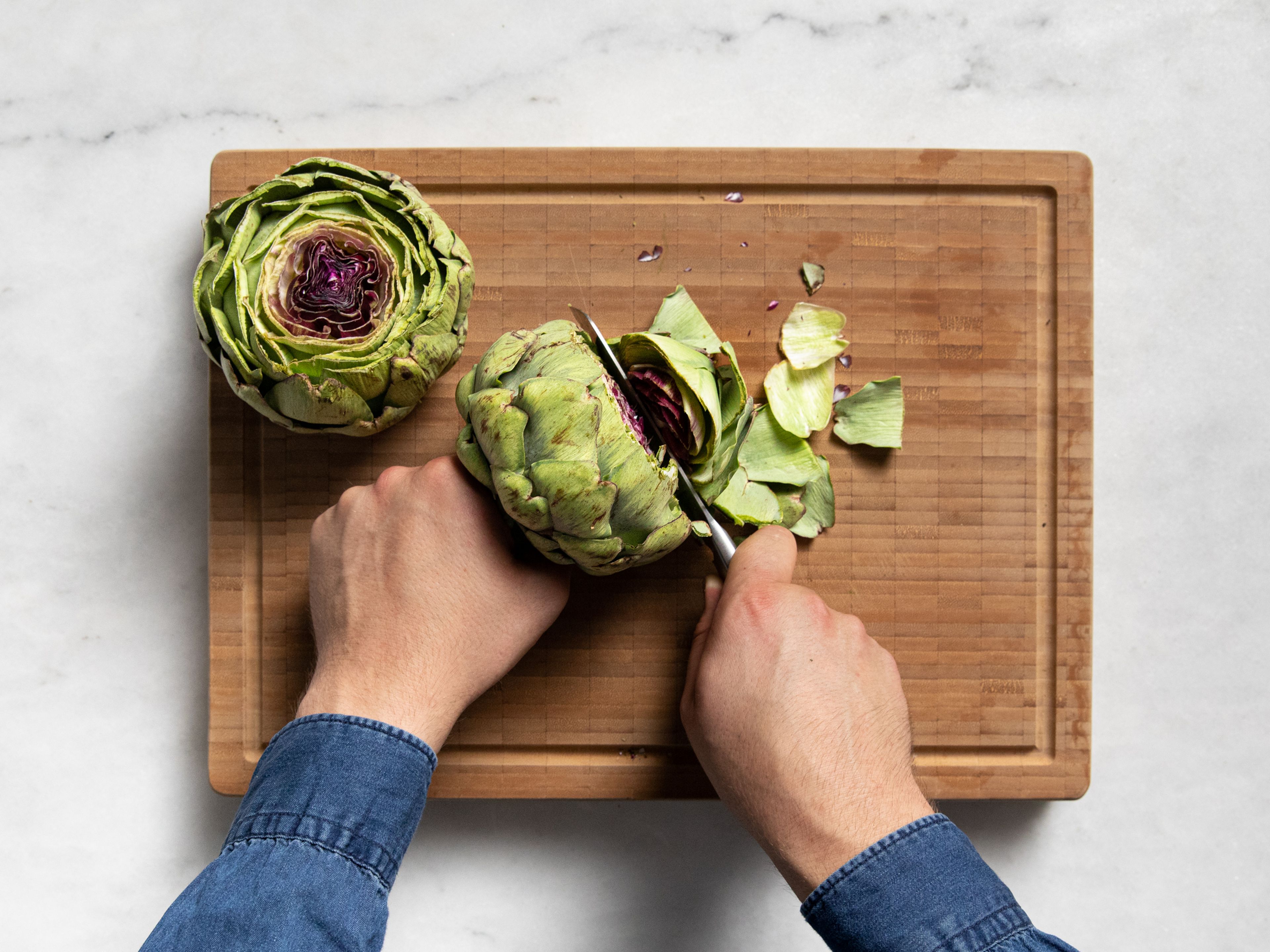 Bring a big pot with water and salt to a boil. To prepare the artichokes, cut off about 2 cm/1 in. from both the stem and top with a serrated knife.