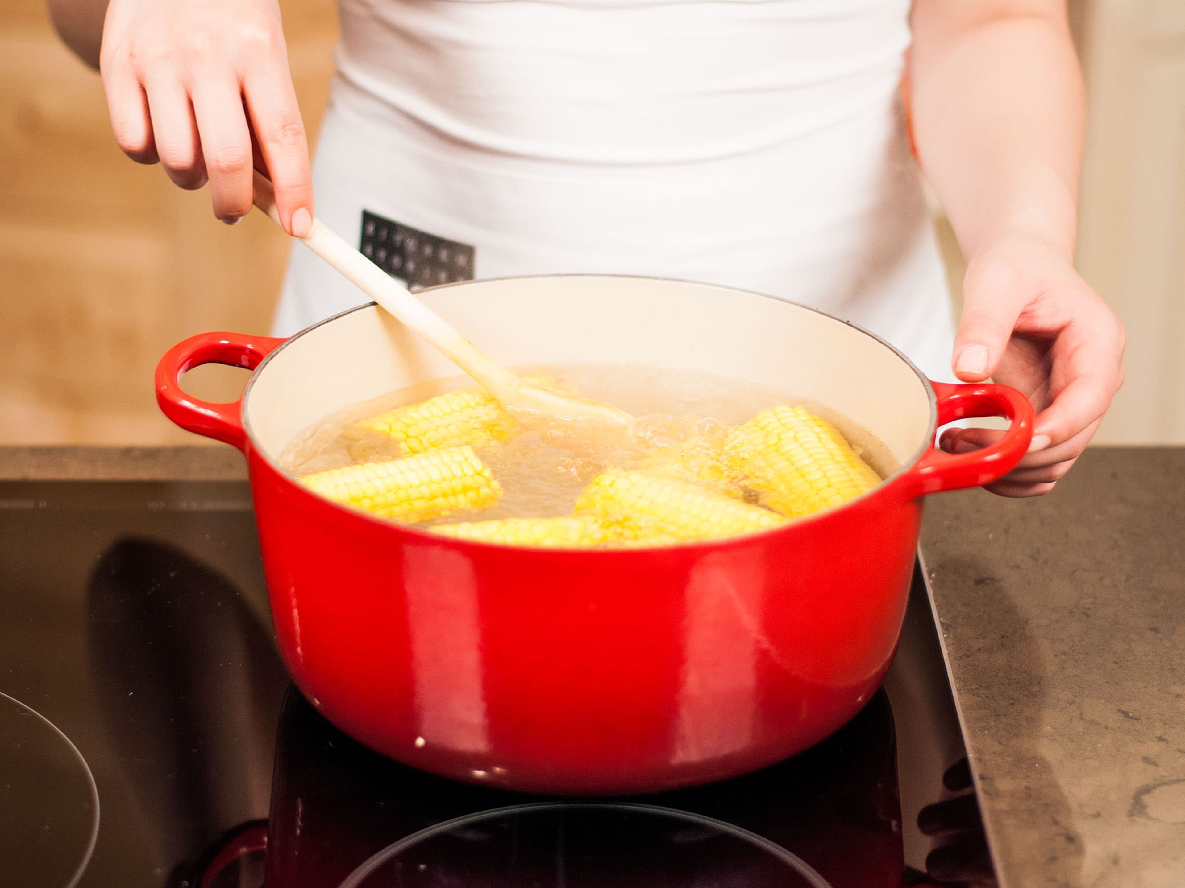 Preheat the grill. Cut off the tough ends of sweet corn and divide into serving sizes. Precook sweet corn in salted boiling water for approx. 15 – 20 min.