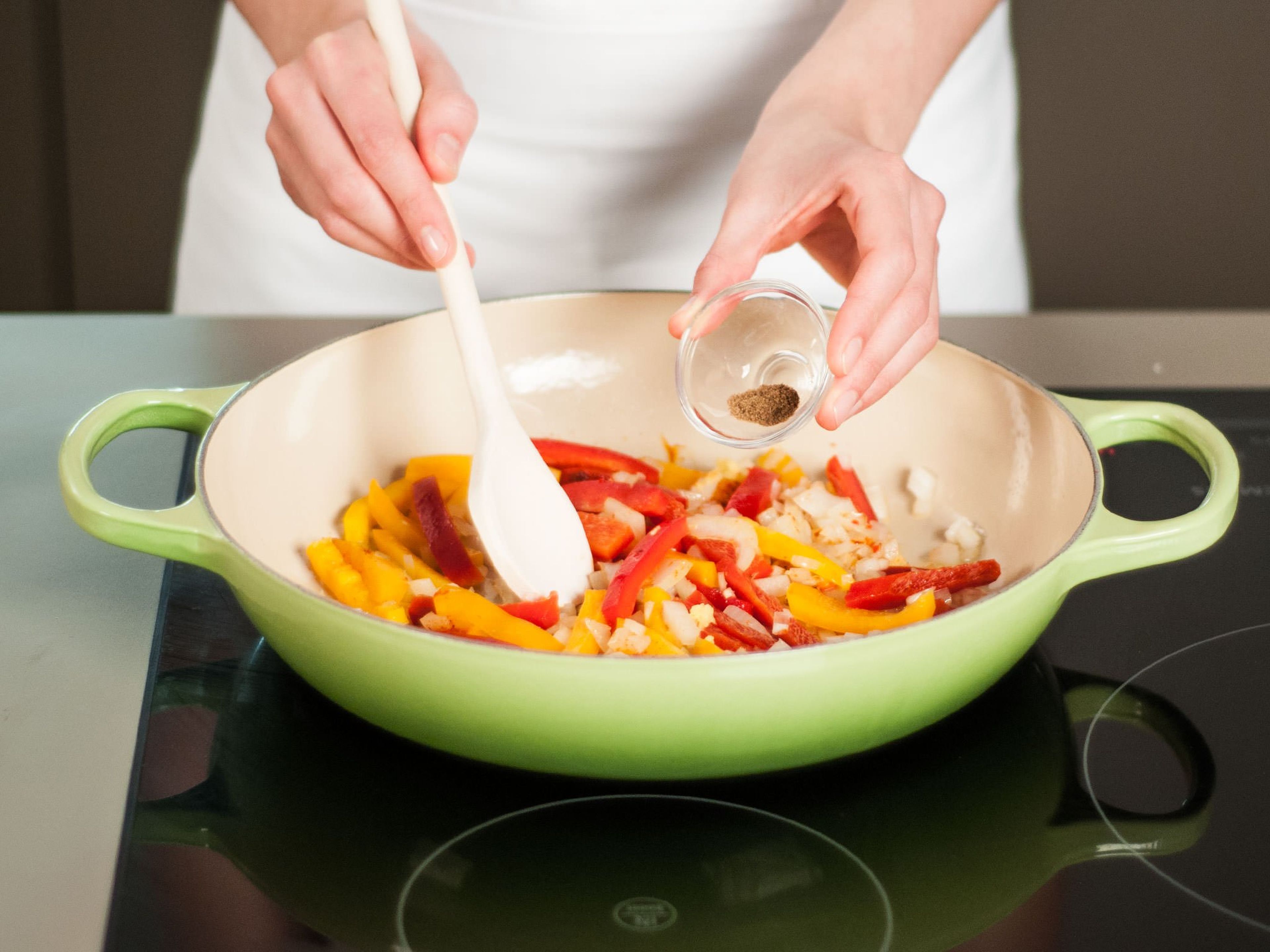 Zwiebel, Knoblauch, Ingwer und Chili fein würfeln. Paprika in feine Streifen schneiden. Tomaten würfeln. Etwas Pflanzenöl in einer Pfanne auf mittlerer Stufe erhitzen. Zwiebel, Knoblauch, Chili und Paprika dazugeben und ca. 6–8 Min. weich dünsten. Dann Ingwer, scharfes Paprikapulver und Kreuzkümmel hinzufügen und ca. 2 Min. mitbraten.