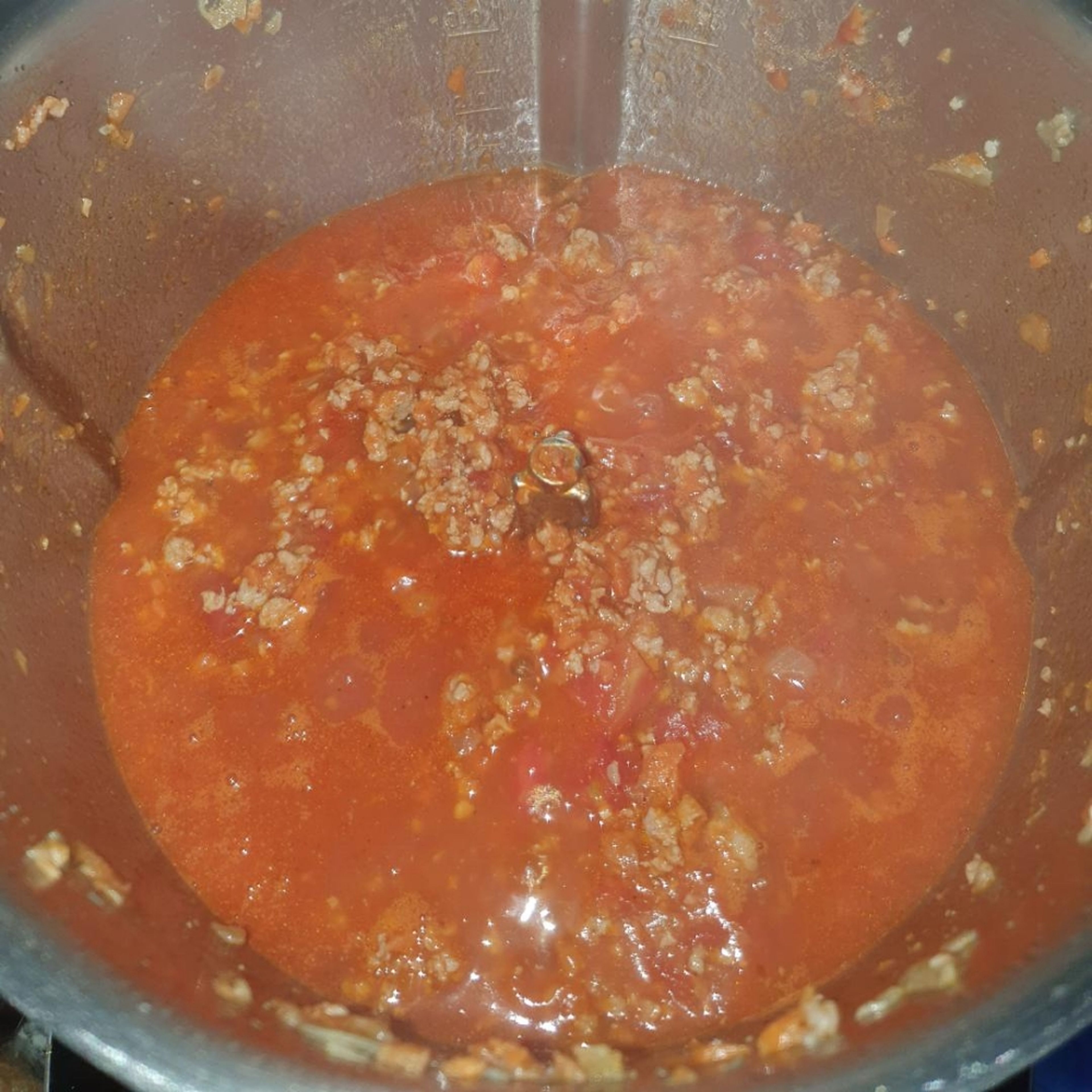 Tomatenmark und gehackte Tomaten unterrühren, mit Salz, Pfeffer und Zucker würzen und ca. 2 Min. bei geöffnetem Deckel mit anbraten (ohne Werkzeug | 160°C | 2 Min.). Immer wieder mit dem Spatel umrühren. Dann mit Gemüsebrühe ablöschen. Auf 120°C stellen bis es aufgekocht ist, dann auf 97°C reduzieren und bei geschlossenem Deckel, ohne Messbecher, ca. 5 Min einkochen lassen (ohne Werkzeug | 97°C | 5 Min.). 1-2 Mal mit dem Spatel umrühren.
