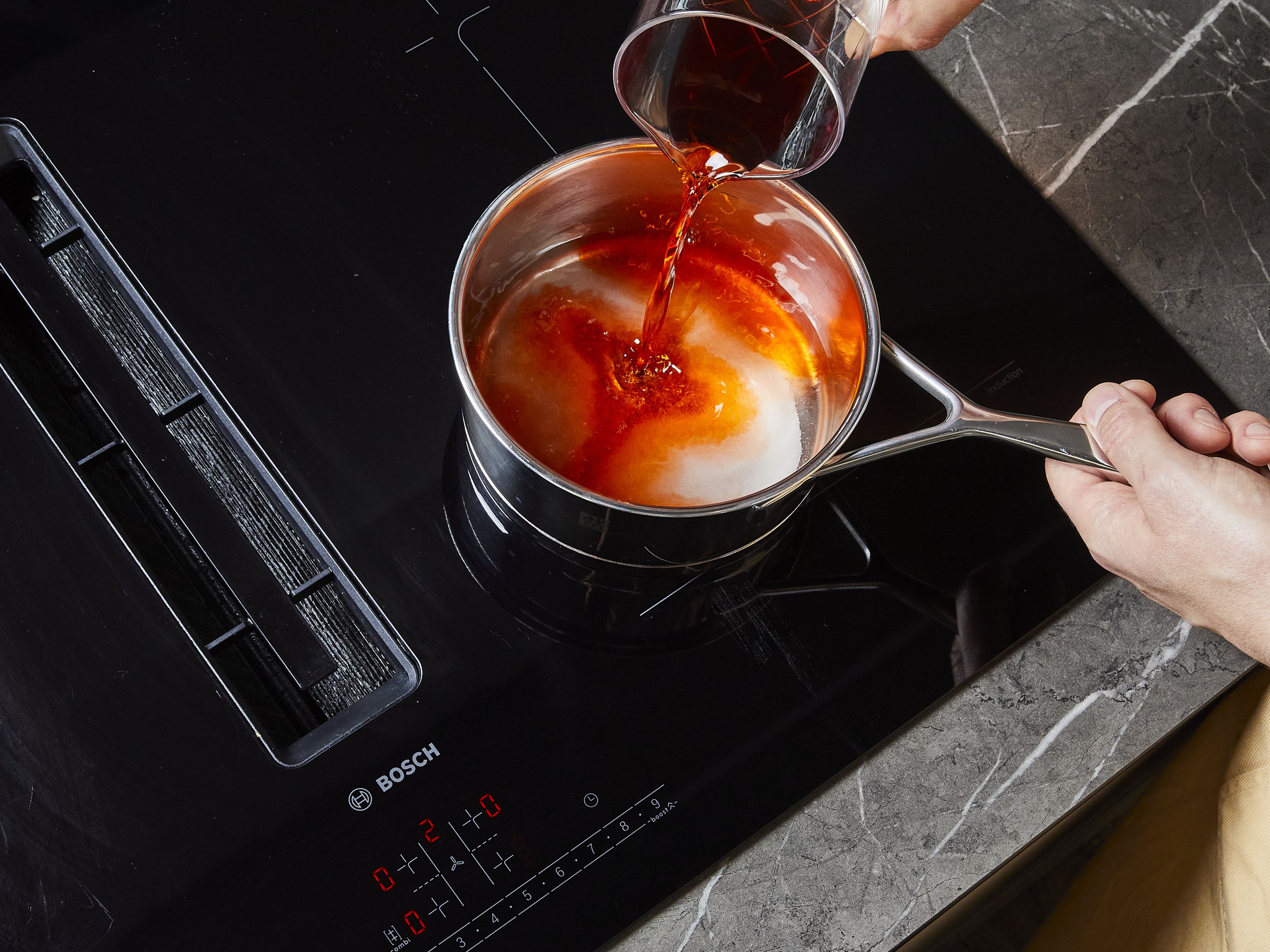 Für den Sirup ⅓ des Aperols, die Hälfte des Weißweins sowie einen Teil des Zuckers und des Wassers zusammen aufkochen und leicht köcheln lassen, bis sich der Zucker aufgelöst hat und der Alkohol verkocht ist, ca. 2 Min. In eine Schüssel umfüllen und beiseite stellen.