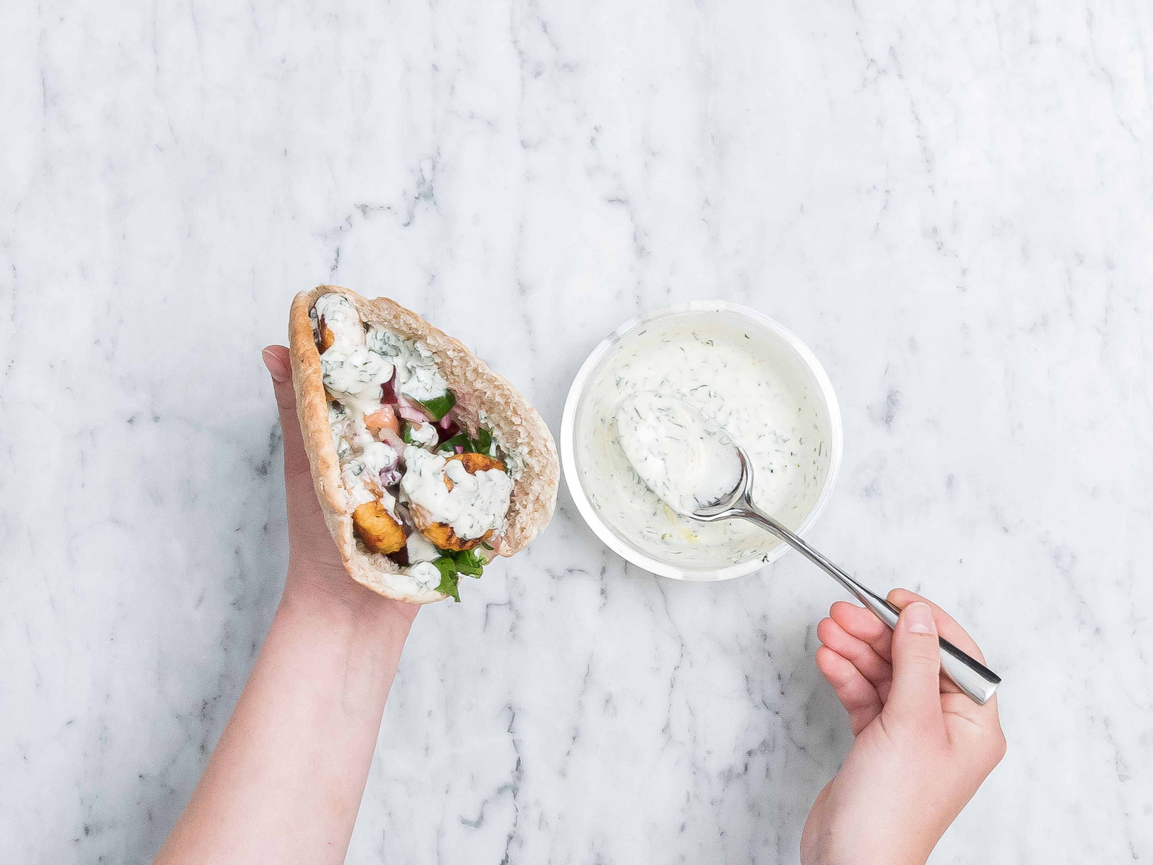 Pitabrote nach Belieben toasten und mit Salat und gebratenen vegetarischen Frikadellen befüllen. Mit Joghurt-Minz-Dip beträufeln. Guten Appetit!