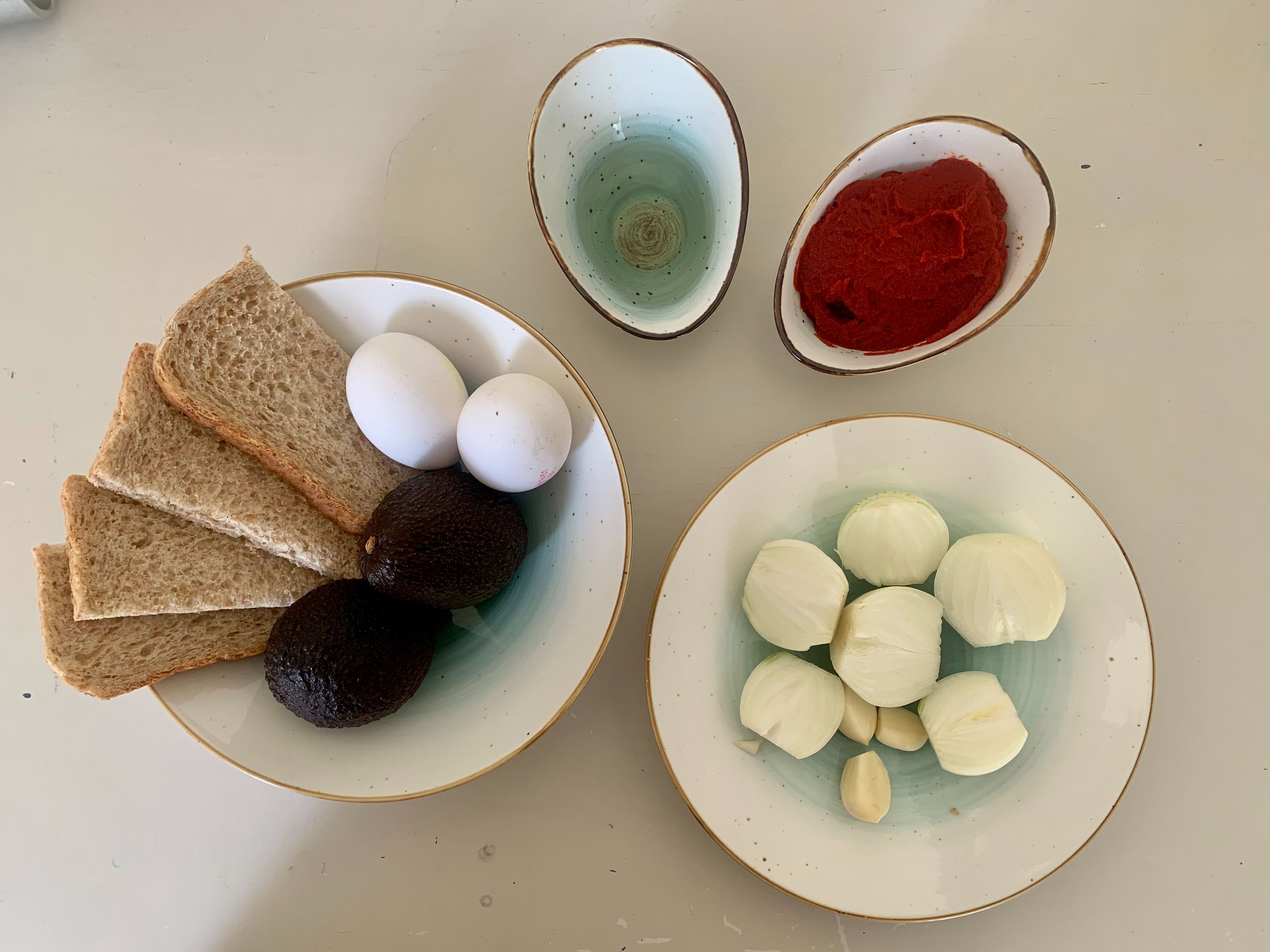Zwiebeln schälen und halbieren, Knoblauch schälen.