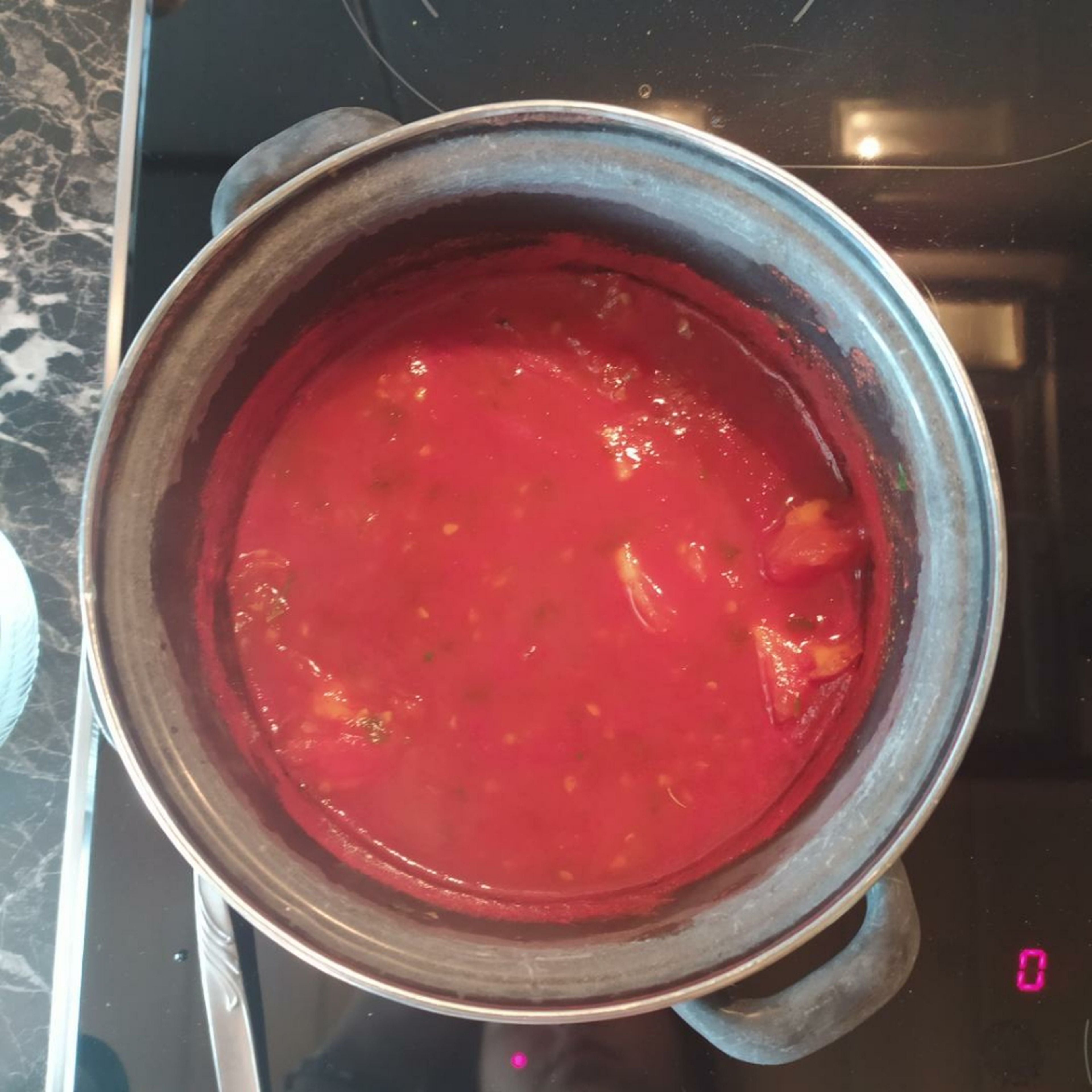 250ml Wasser aufkochen, Gemüsebrühe, Tomateninneres und Tomatenmark einrühren. Petersilie und Oregano hinzufügen. Ca. 2-4 Minuten aufkochen.