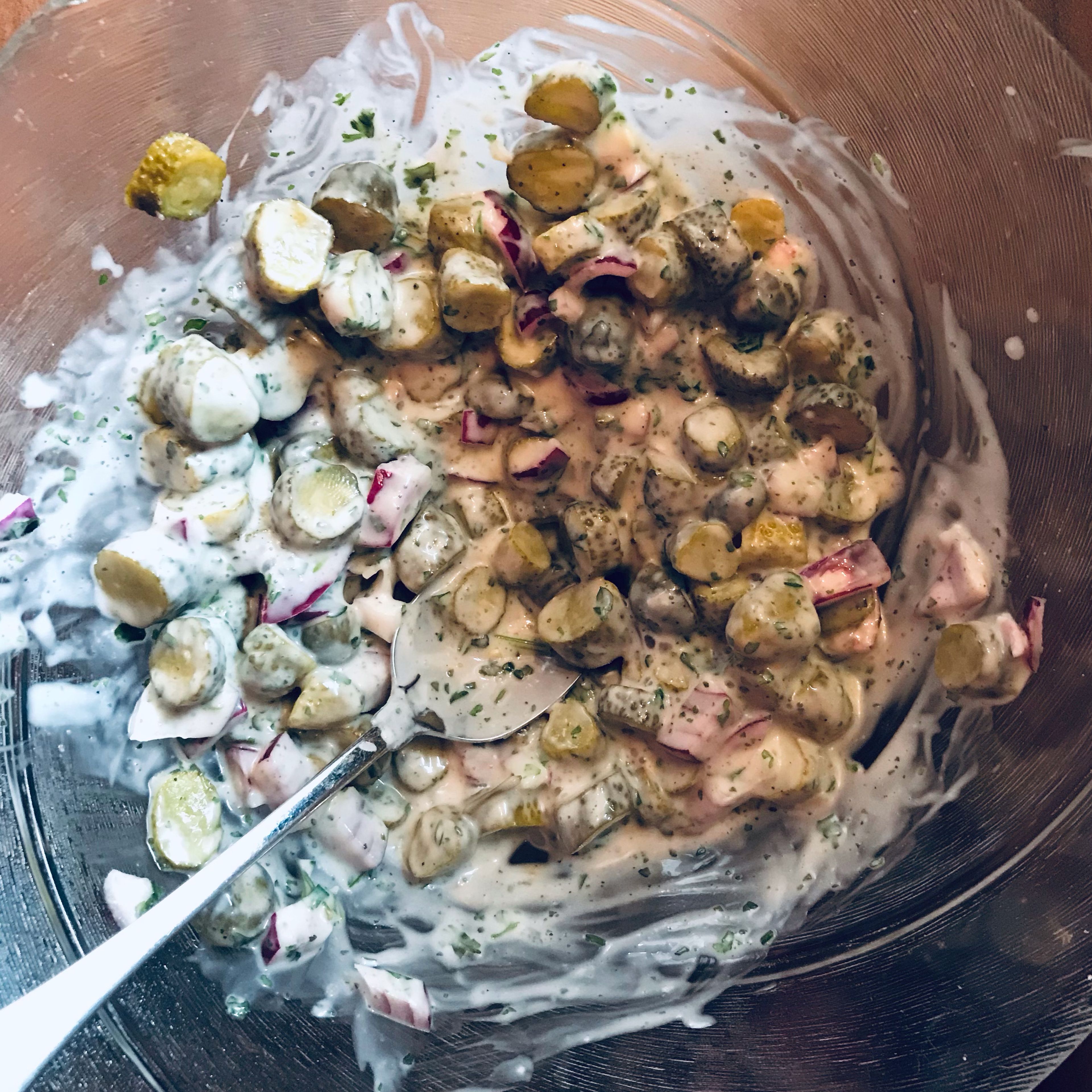 Inzwischen kann die Salatsoße vorbereitet werden. Die Zwiebel klein schneiden mit miracel whip vermengen. Die Kräuter und das Gurkenwasser zufügen. Auch die Gurken können schon reingeschnitten werden. Alles gut vermengen und mit Salz und Pfeffer würzen.