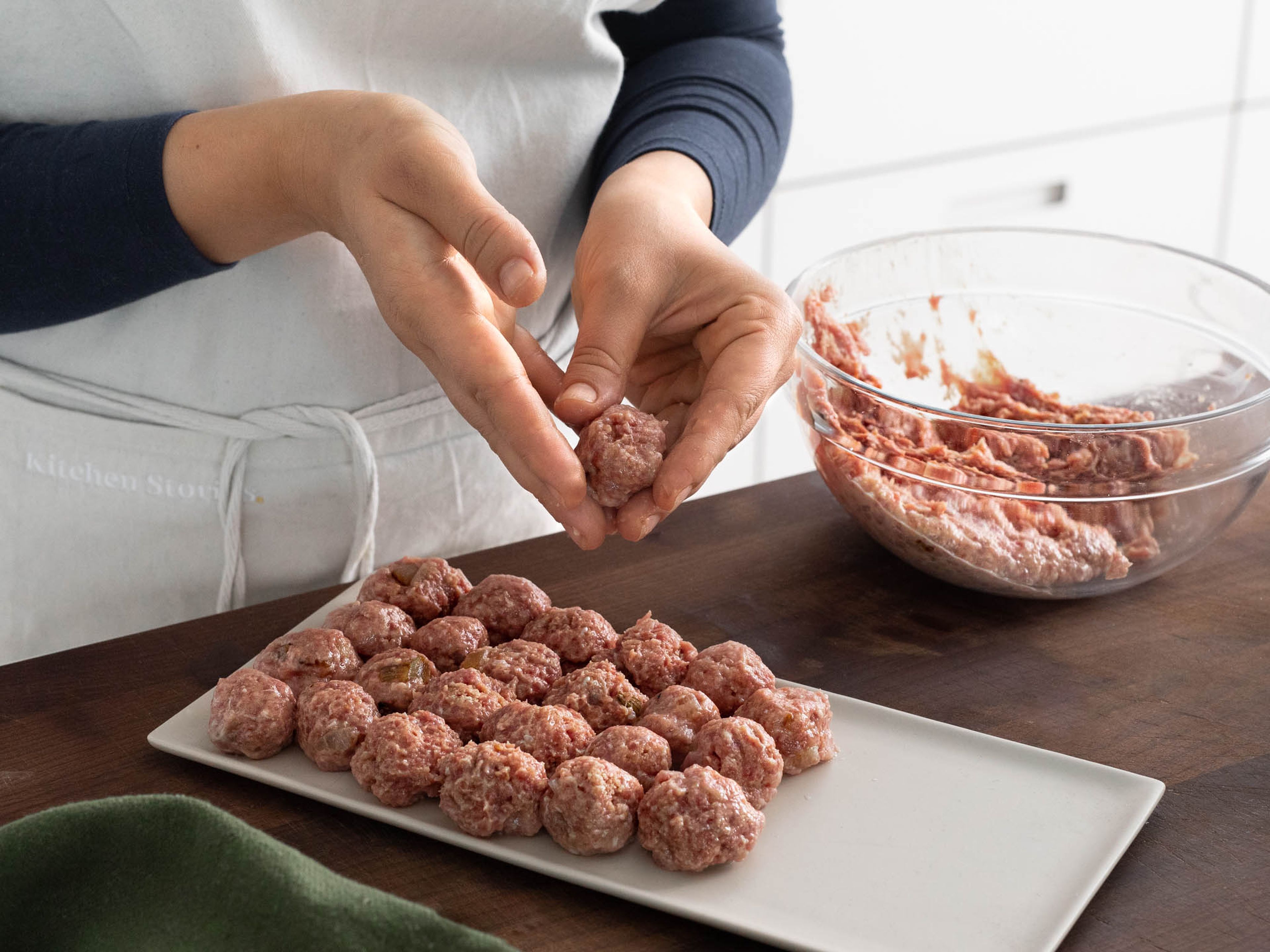 Heat vegetable oil in a pan, then add onion and garlic and sauté until golden brown. In a large bowl, mix ground veal with sautéed onion, garlic, soaked bread roll, and egg. Season with salt, pepper, and allspice. With your hands, form the mixture into meatballs.
