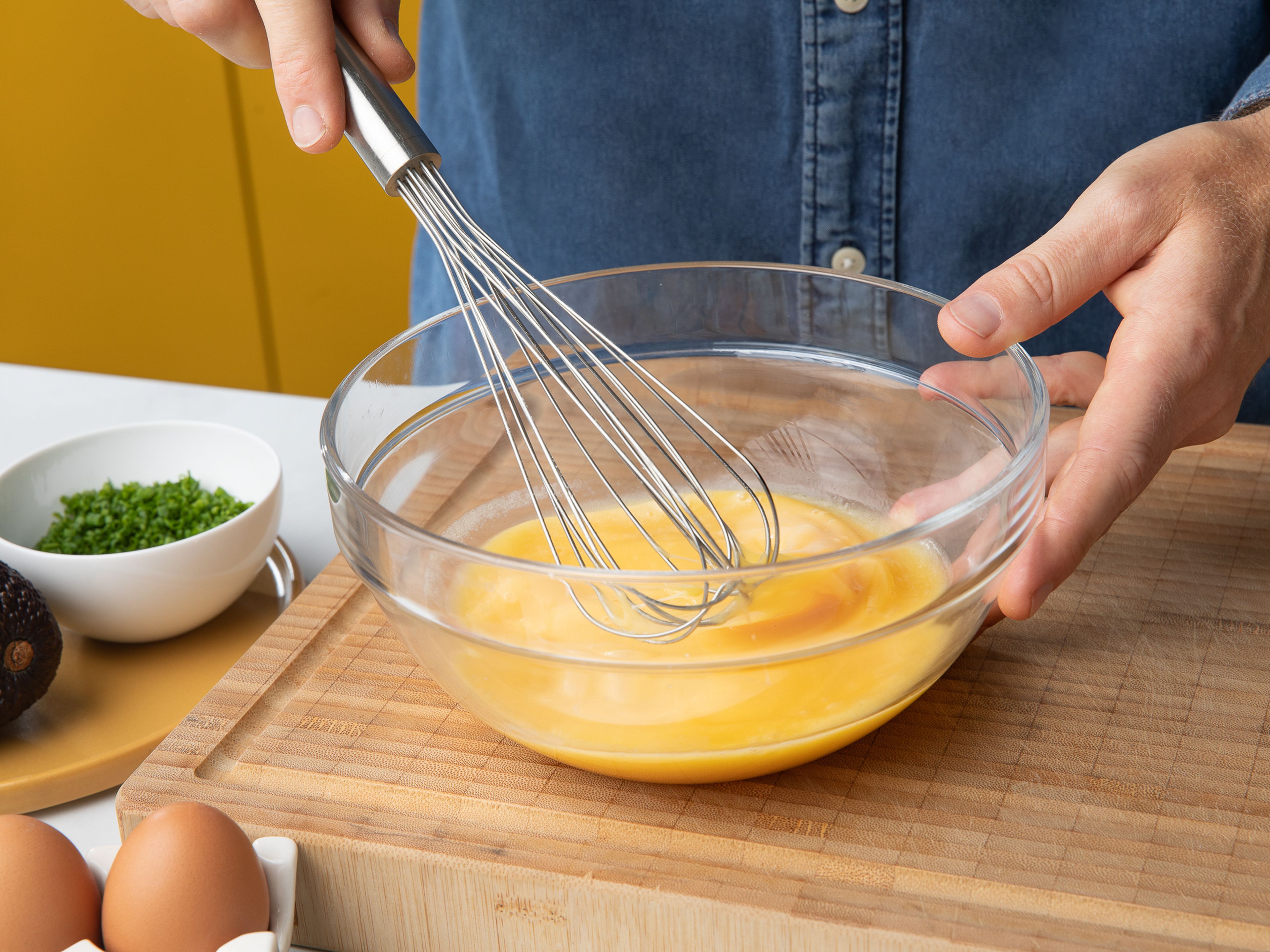 Jede Toastscheibe mit Butter bestreichen, dann die Eier mit Sahne und Salz verquirlen. Die Avocado halbieren, den Kern entfernen und mit einem Löffel aus der Schale lösen. Schneide die Avocado nun der Länge nach in 5 mm dicke Scheiben. Mayonnaise mit Kondensmilch mischen und in einen kleinen Spritzbeutel füllen, dann den Schnittlauch fein schneiden.