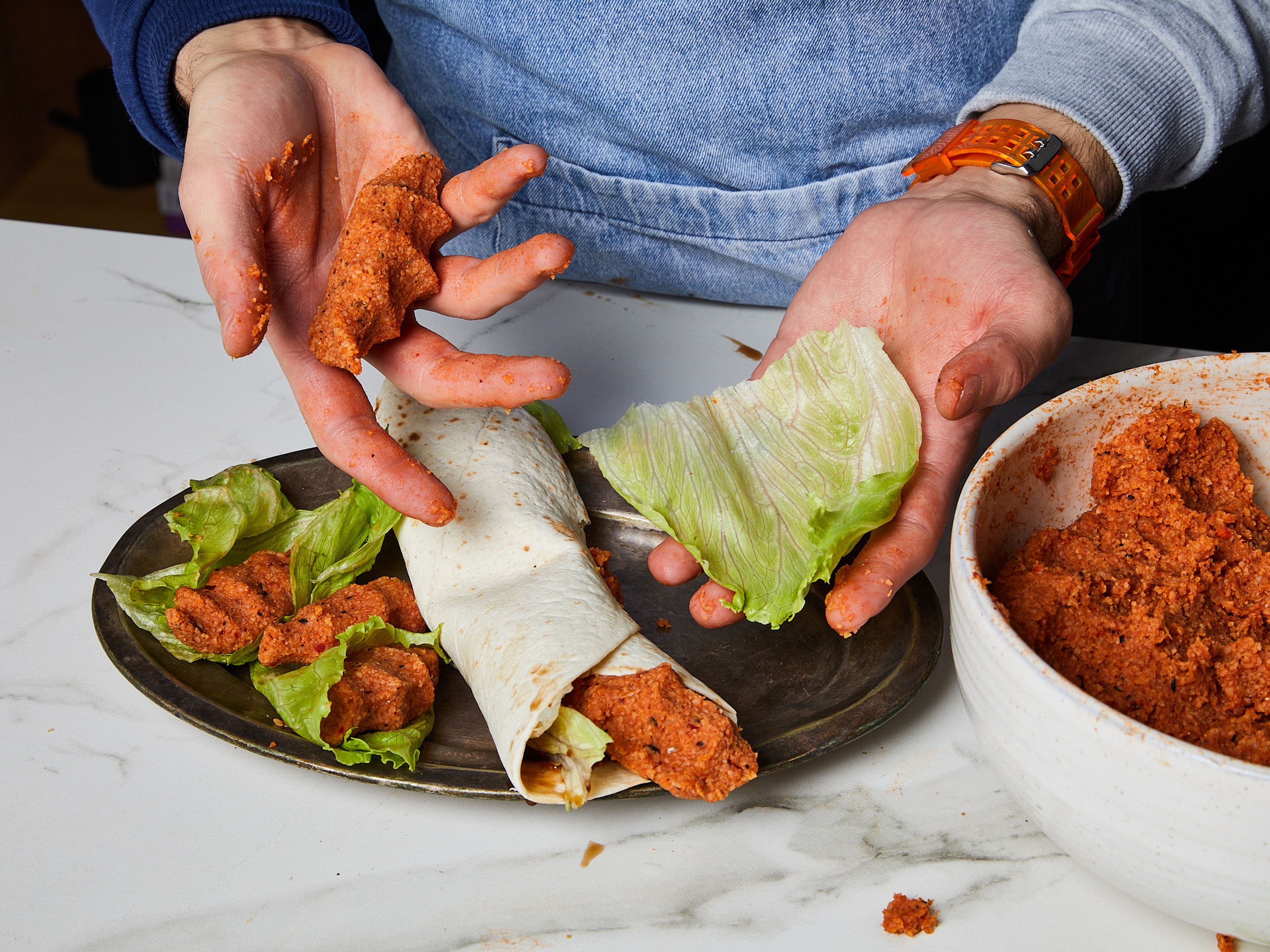Once everything is thoroughly mixed, take a piece in your hand and make sure it is not too dry or too wet. Add more bulgur or water in accordance. You will have a good consistency when you can form solid balls. For a classic çiğ köfte shape, take a ball into your hand and squeeze lightly within your fist.