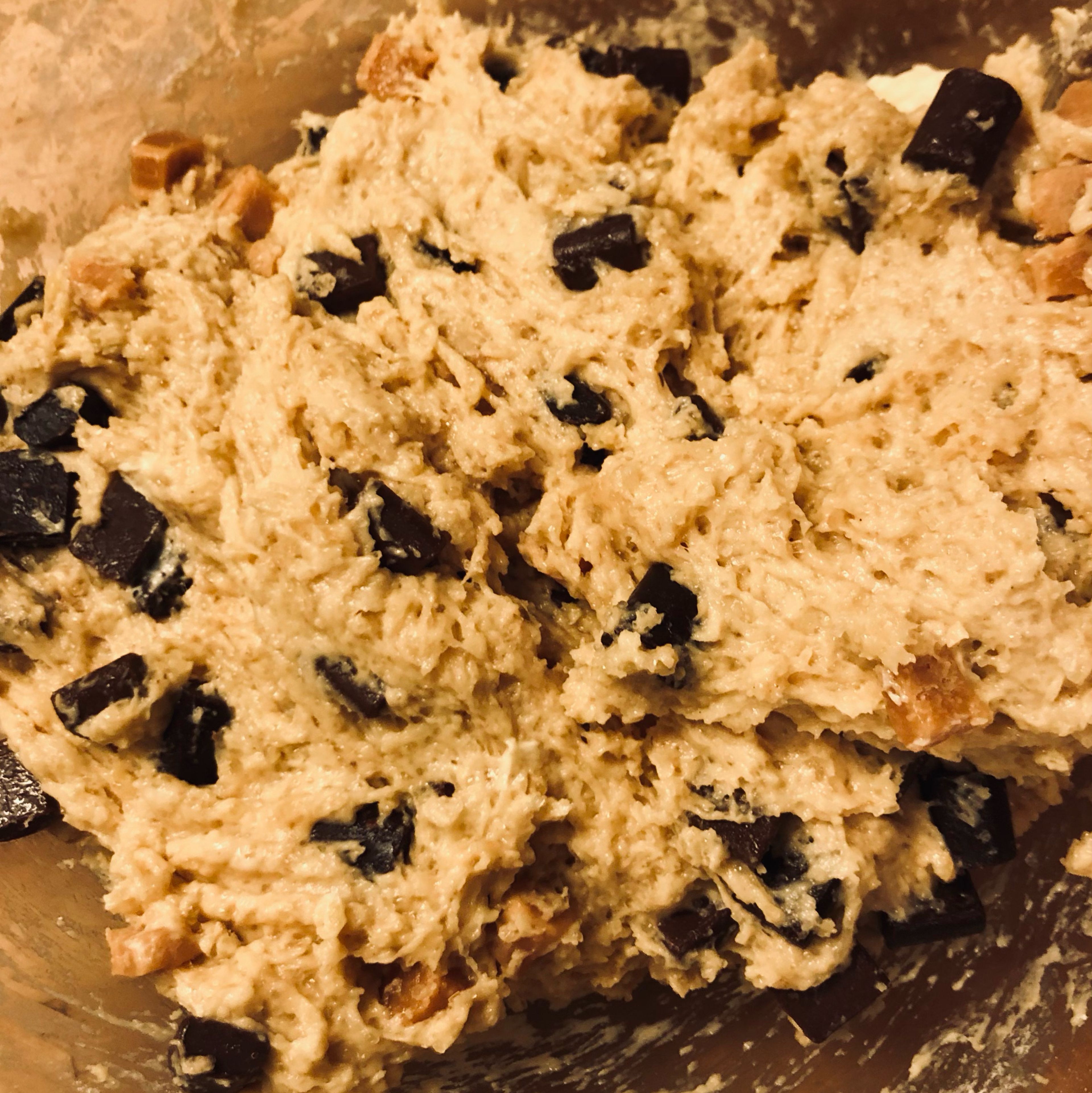 To this bowl, Gently add in the dry ingredients and mix well ( if too dry add a tablespoon of oat milk). Then, using a rubber spatula, fold through the salted caramel and chocolate chips.