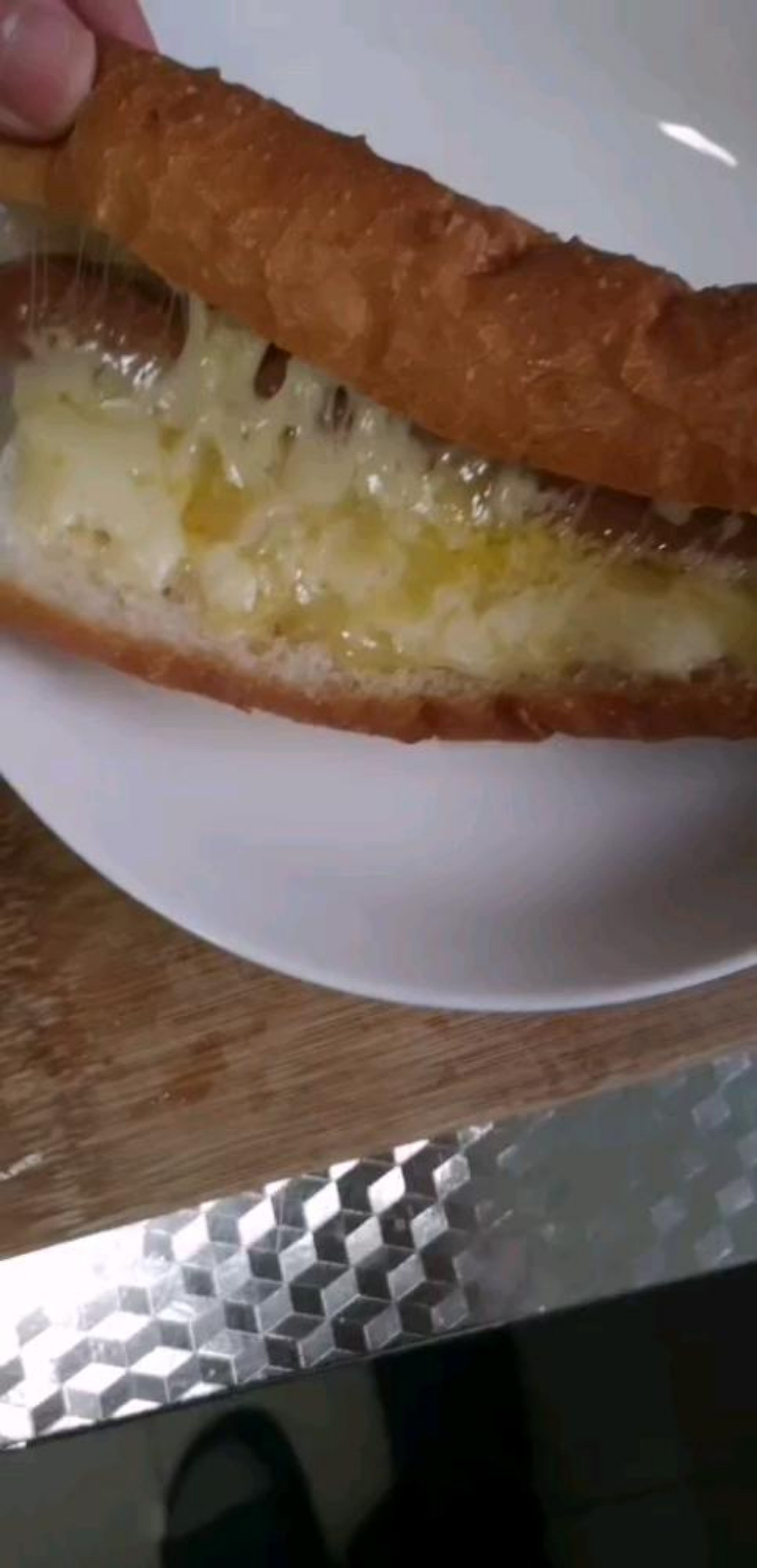 Take the baguette, cut it in 3 pieces and slice each piece in half. Then insert the sausage on each piece of bread and fill it with the shredded cheese. After that heat the pieces in the microwave for 45 seconds to melt the cheese.